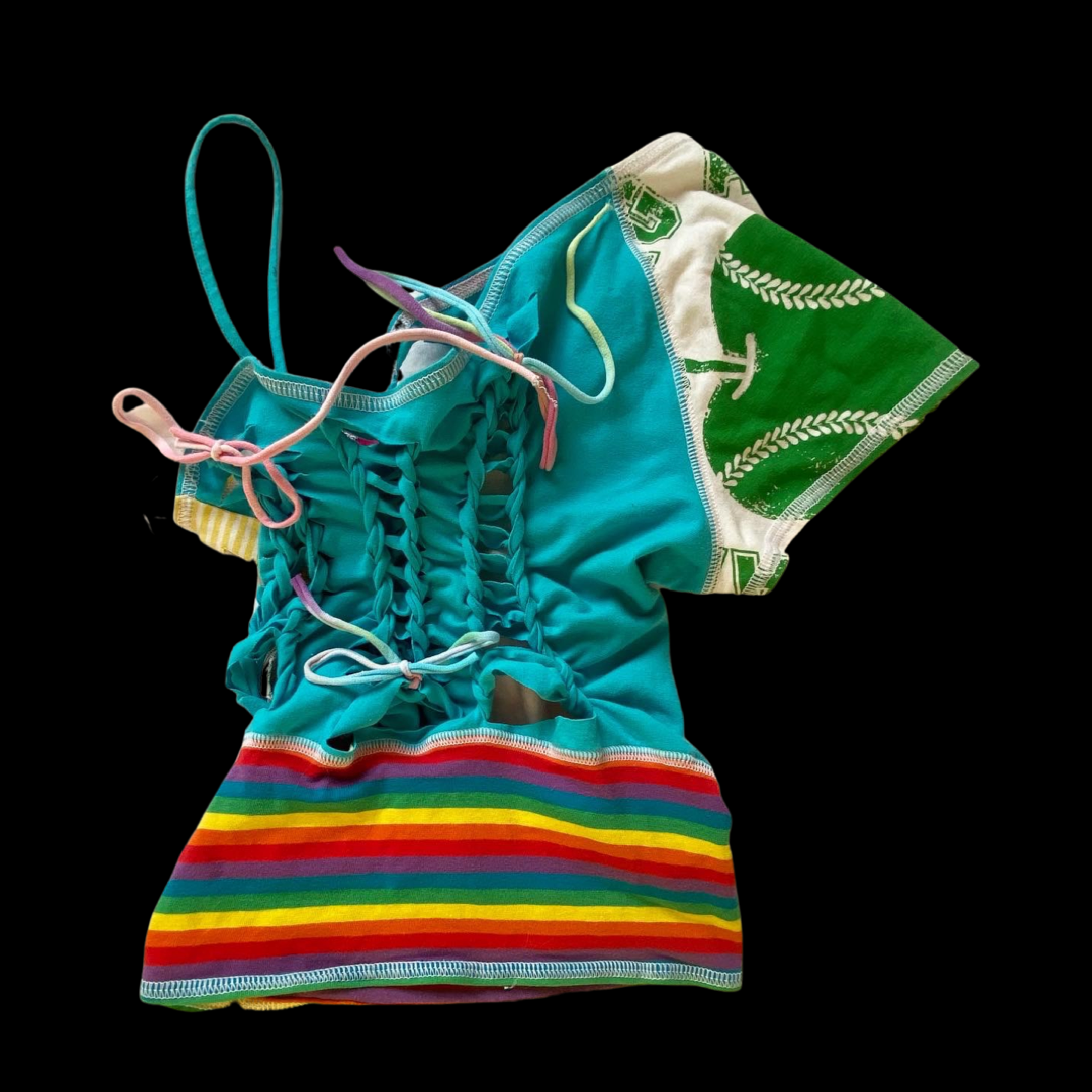 Colorful swimsuit with rainbow stripes and a turquoise top, accompanied by a pattern towel with a green and white design, set against a black background.