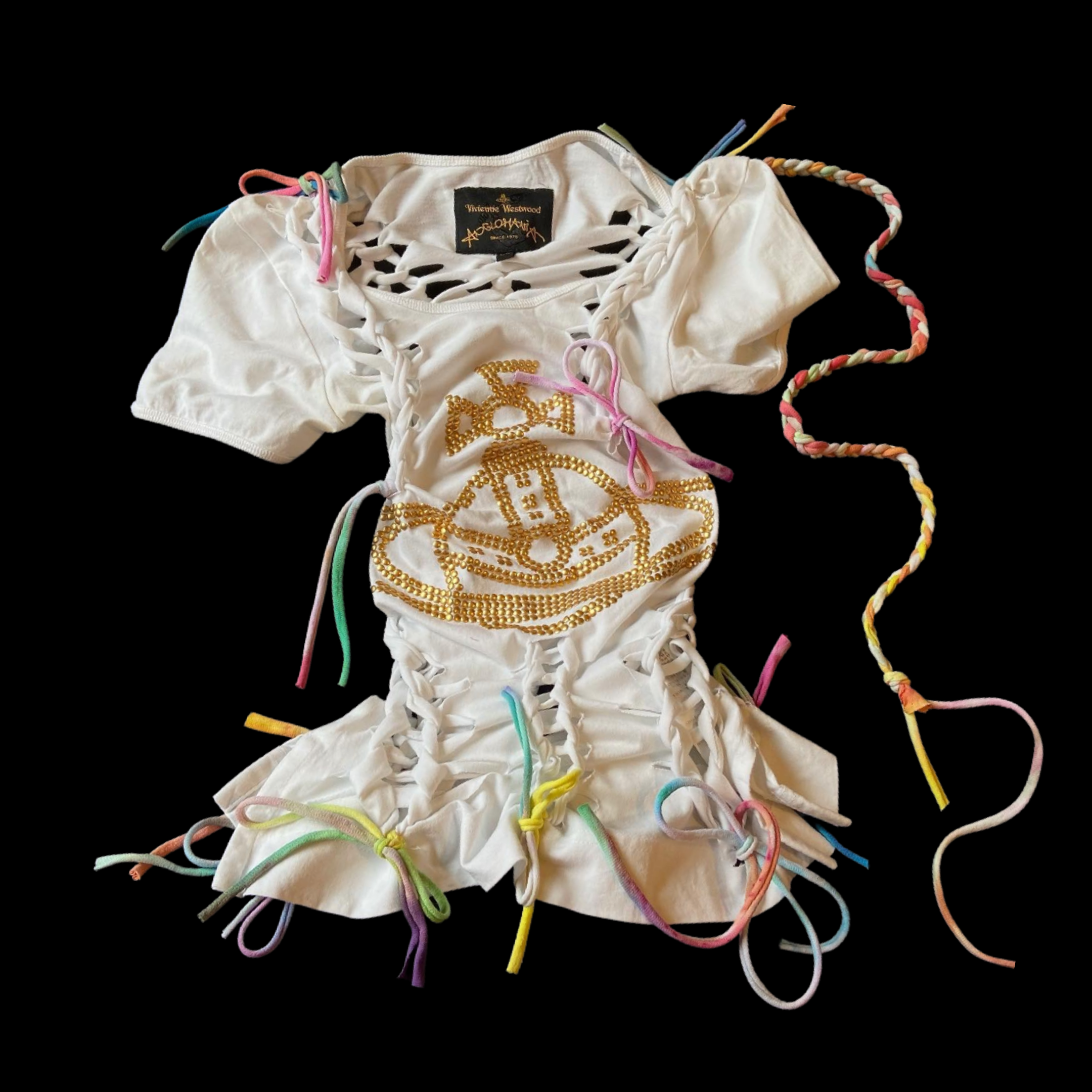 A white Vivienne Westwood and Andreas Kronthaler designed top with cut-out details and colorful ribbon laces, decorated with gold beaded designs resembling a face, set against a black background.