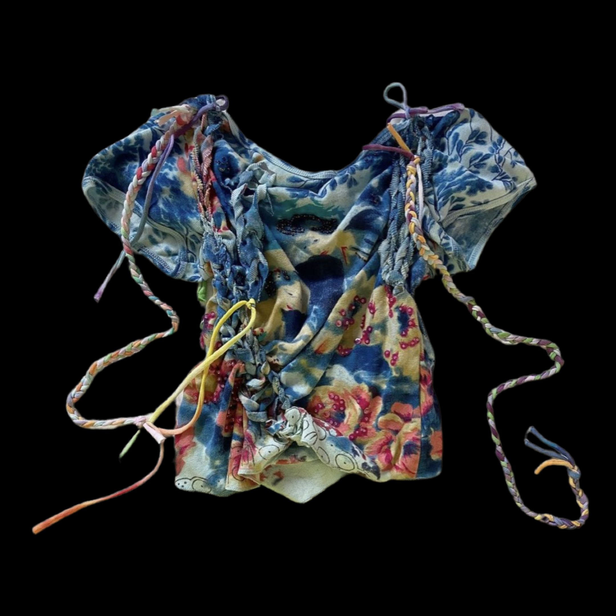 A colorful tie-dye fabric with multiple twisted and braided shoelaces and straps laid out on a black background.
