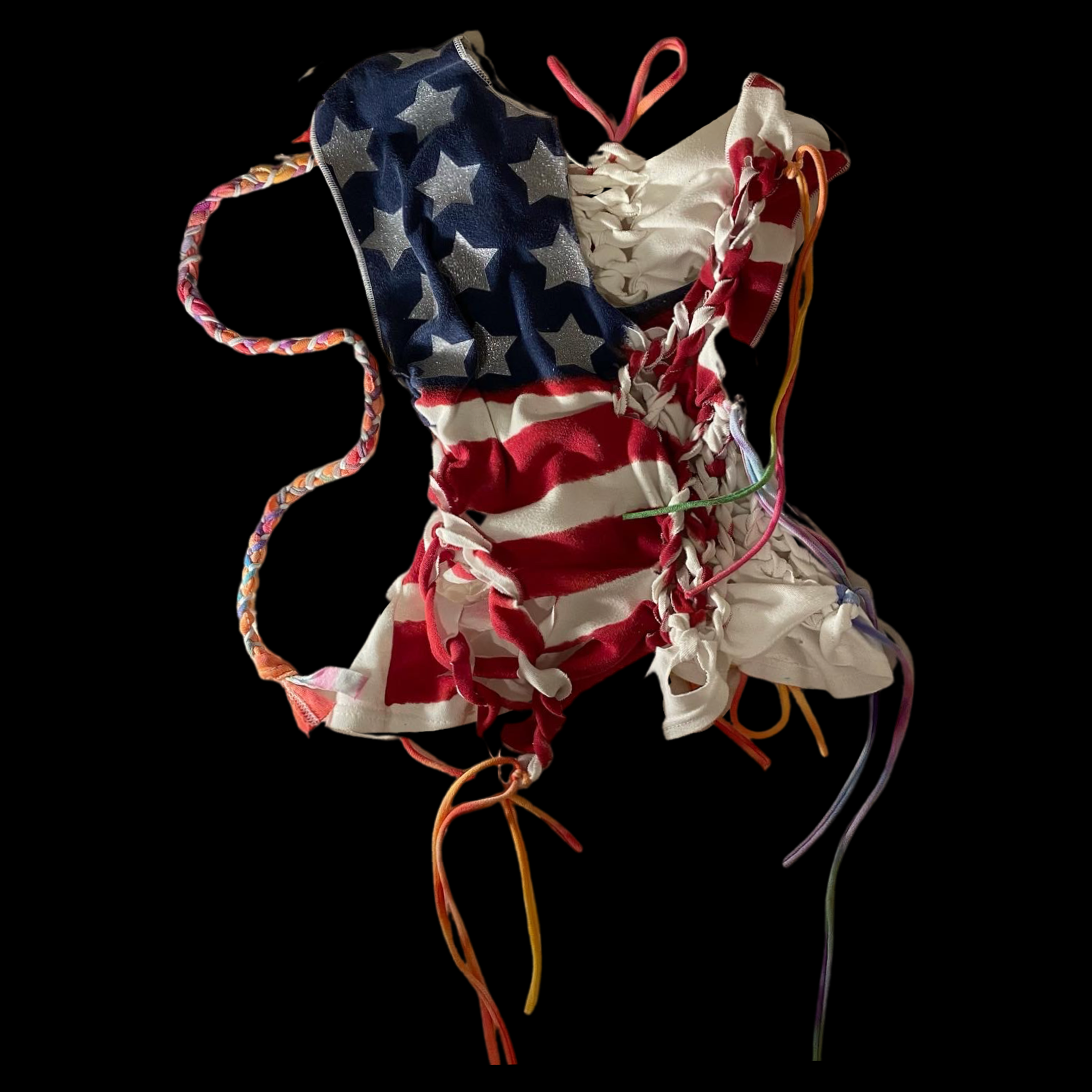 Wrinkled face mask with American flag design, featuring stars and stripes, with colorful ties on a black background.