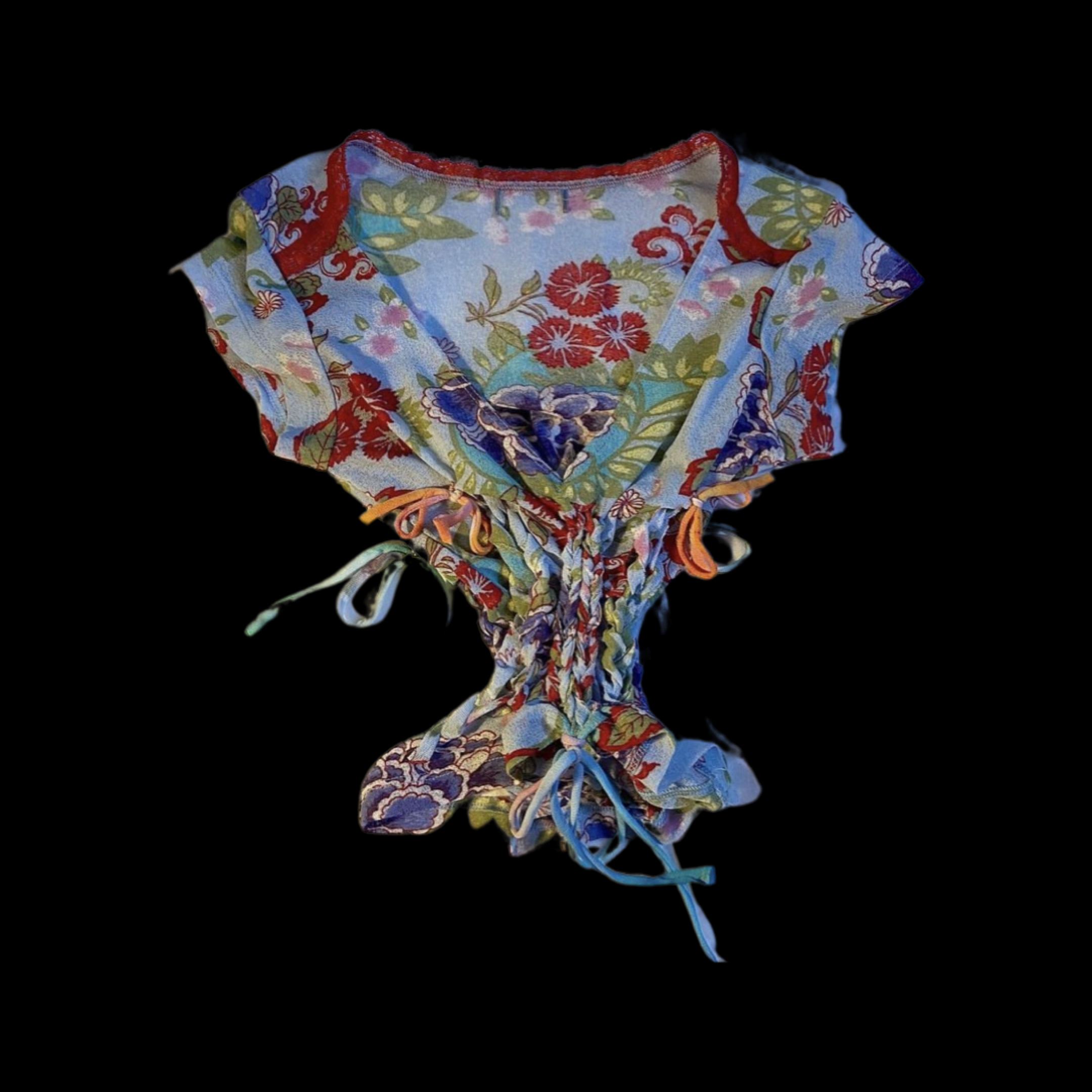 A colorful, floral-patterned fabric garment with ties, set against a black background.
