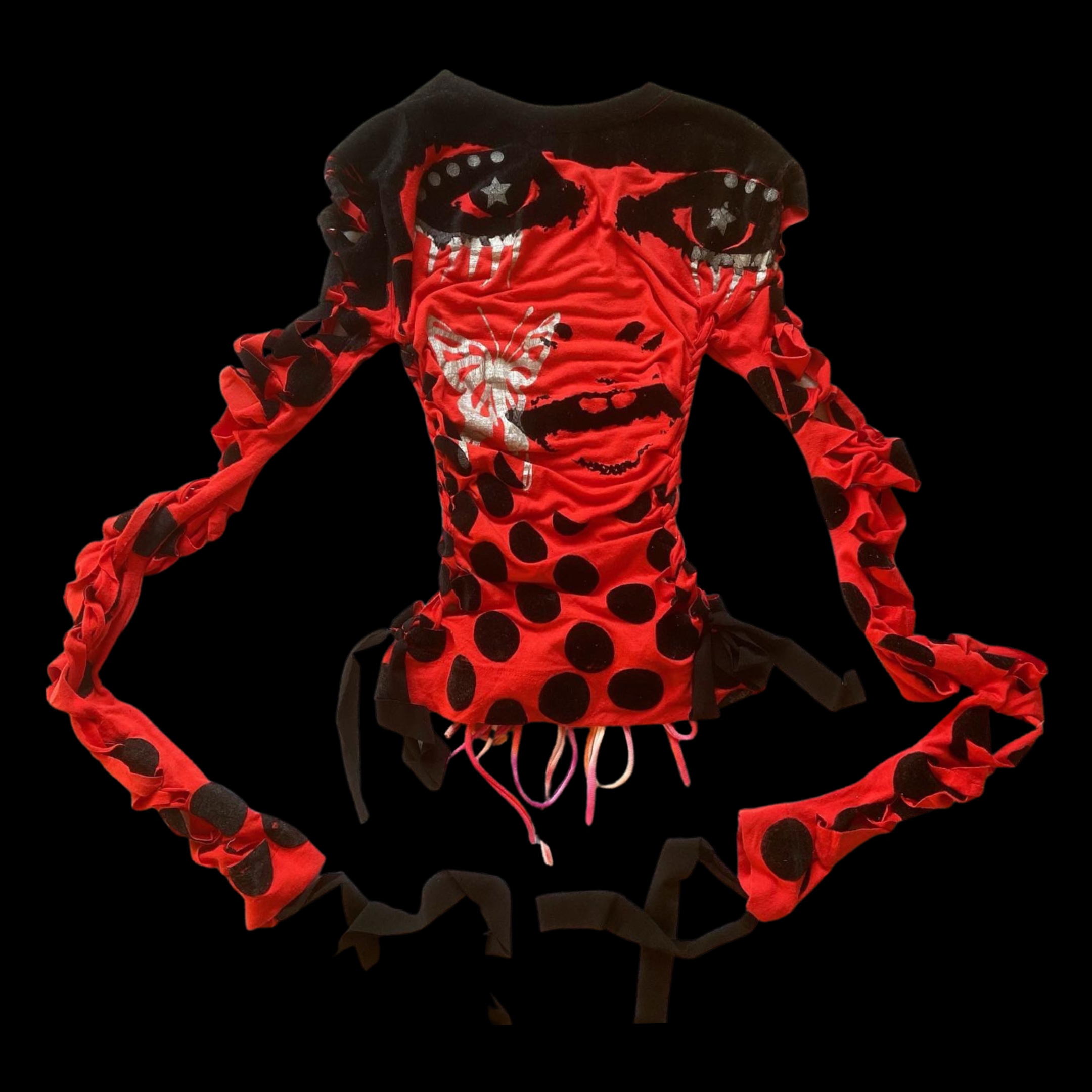 Red long-sleeve top with black polka dots and graphic faces, featuring ruffled sleeves and a drawstring hem, against a black background.