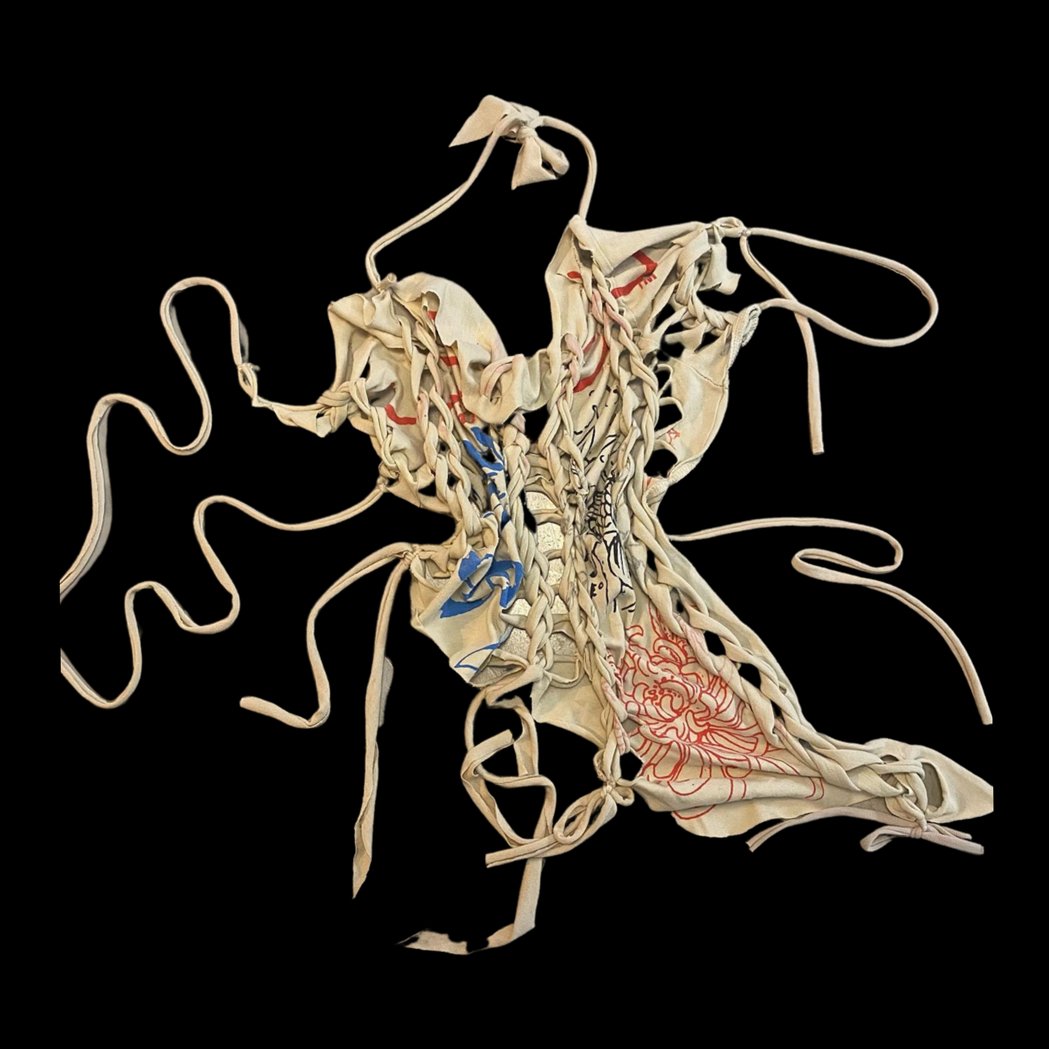 A crumpled fabric with red, blue, and black designs on a black background.