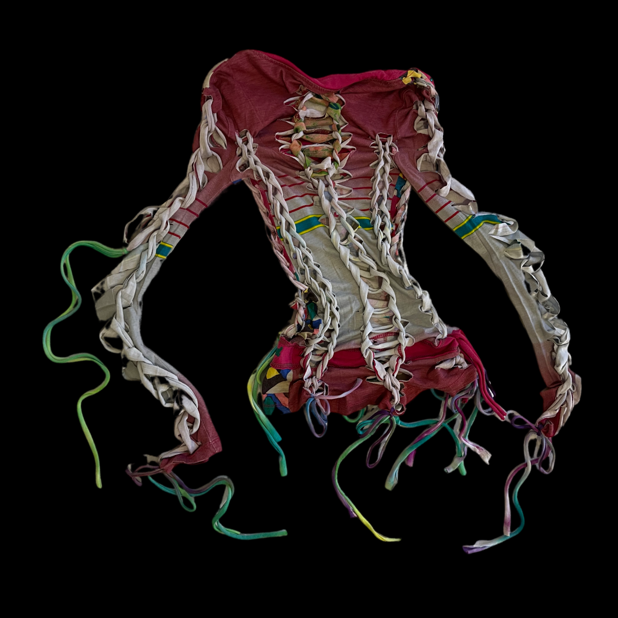 A colorful, tattered corset with laces and ribbons, set against a black background.