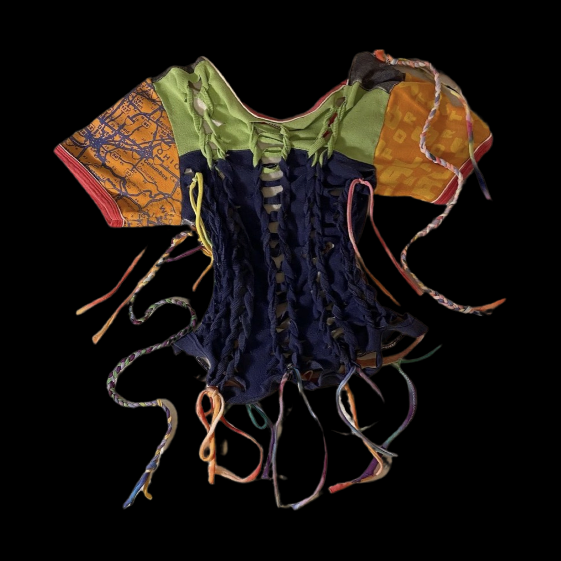 A handmade garment resembling a corset, constructed from fabric pieces in bright colors and patterns, with multiple colorful laces and loops for tying.