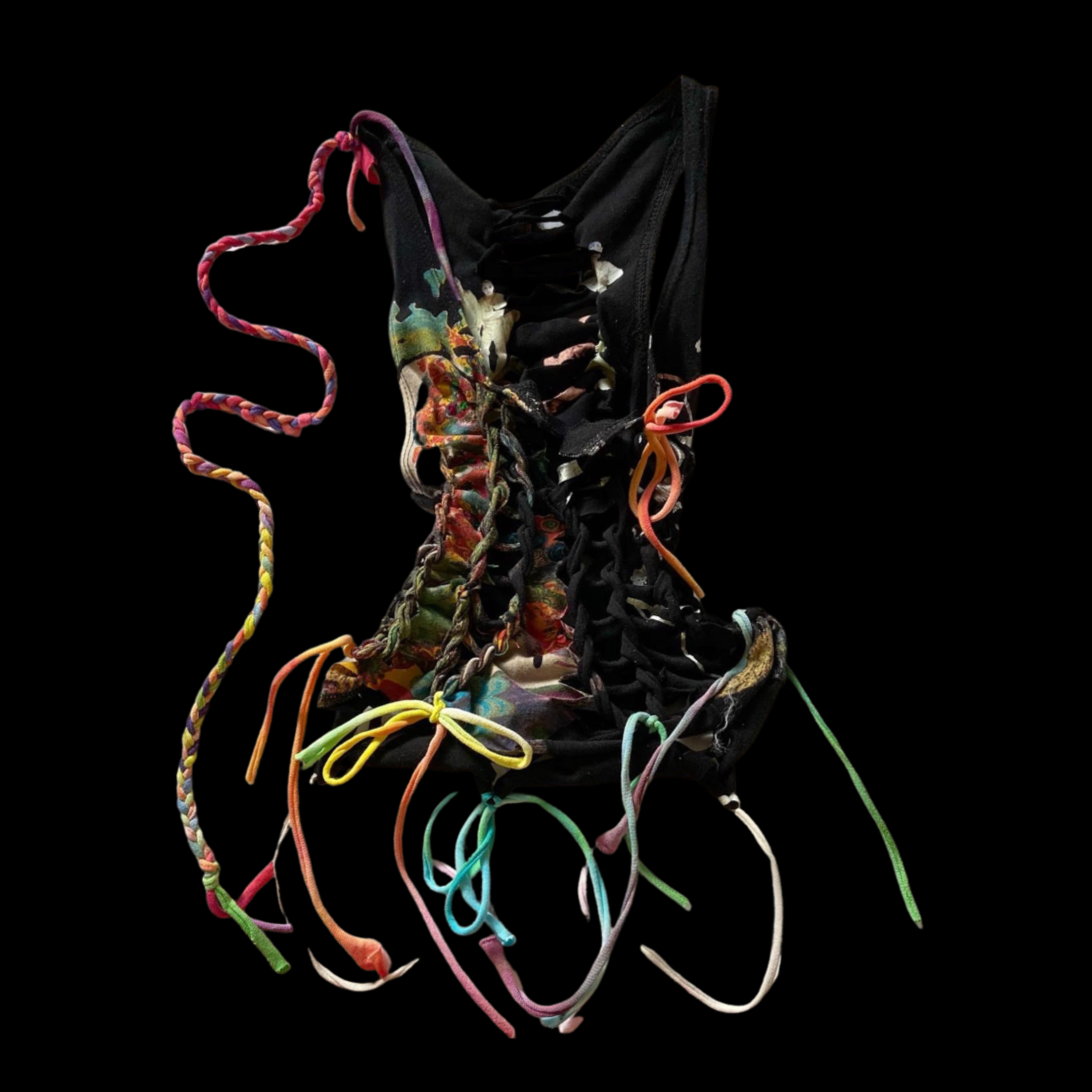 A torn and tangled black fabric shoe with colorful laces and materials, set against a black background.