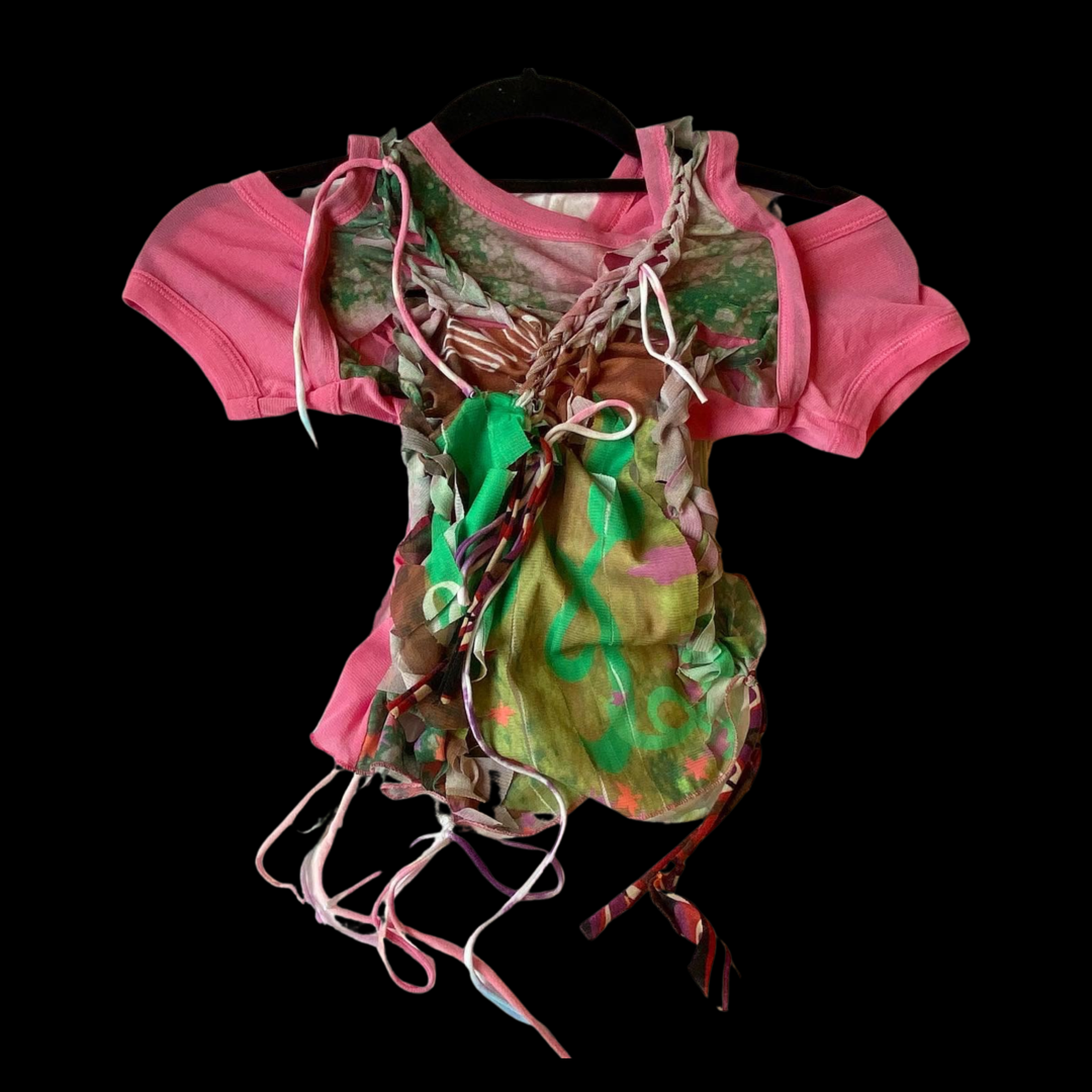 Colorful t-shirt with pink sleeves, decorated with ribbons and a green fabric tied in the front, displayed on a black background.