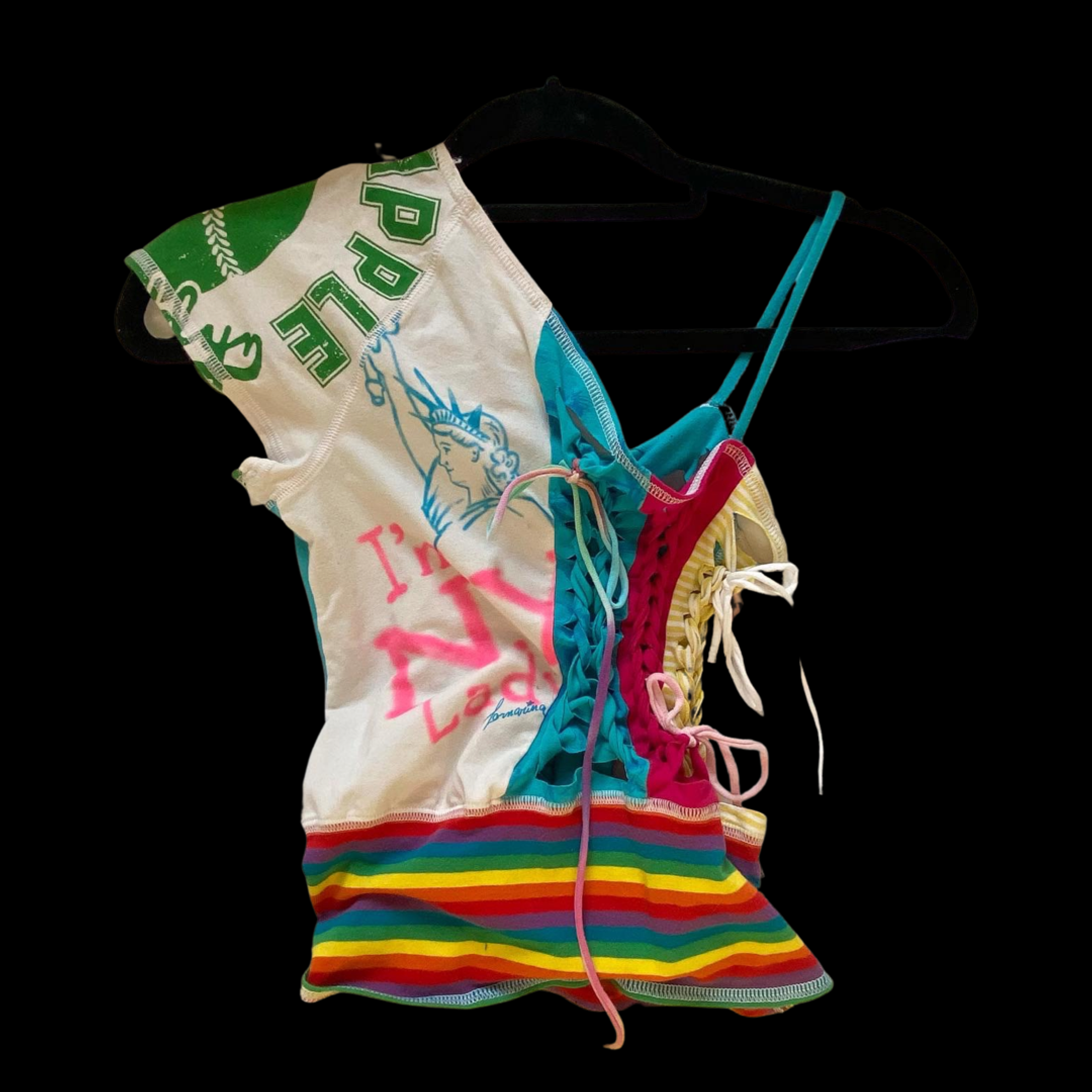 Colorful tank top made from fabric printed with various patterns, including rainbow stripes and a flag design, hanging on a black hanger against a black background.