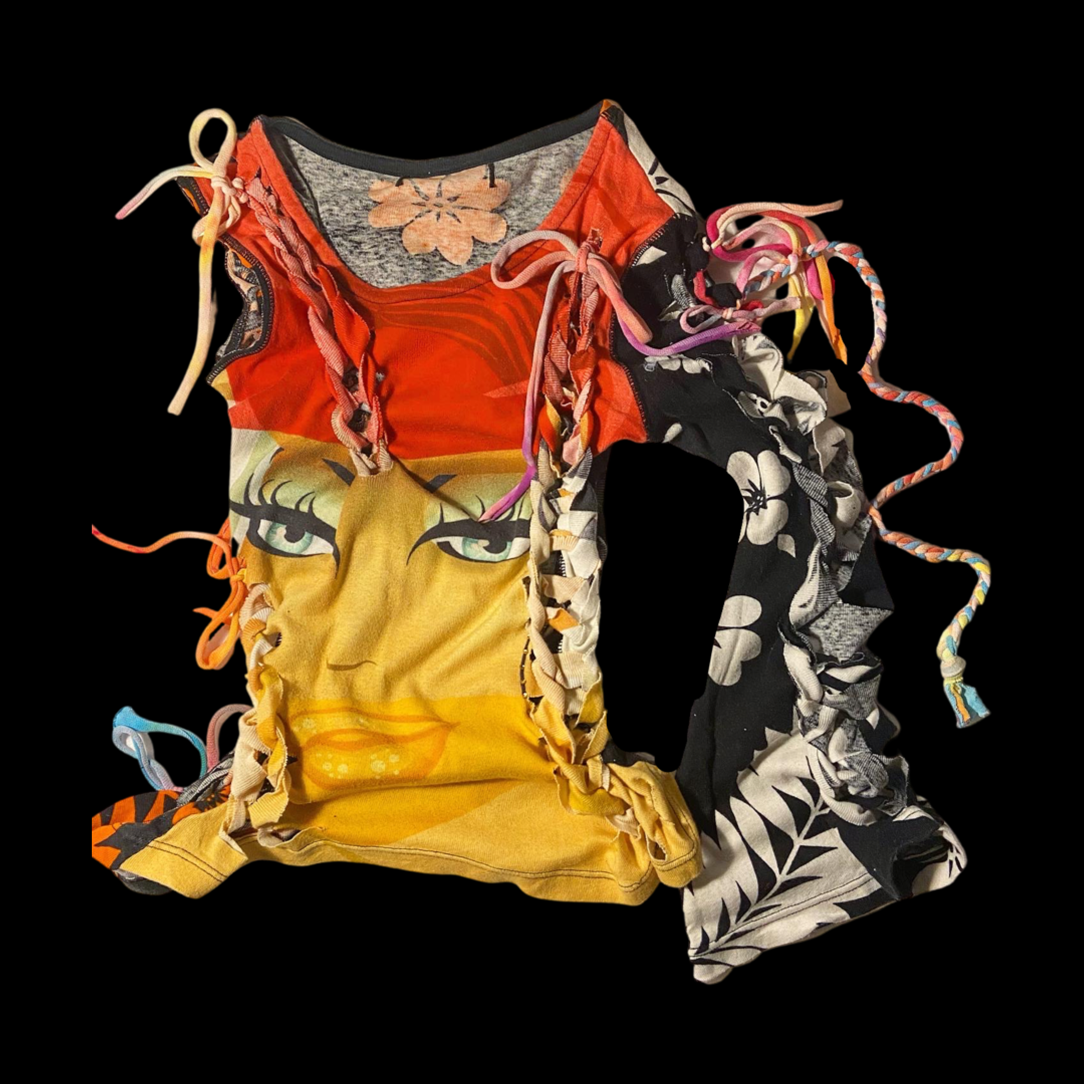 Colorful fabric scraps with floral and face designs, tangled and layered, on a black background.