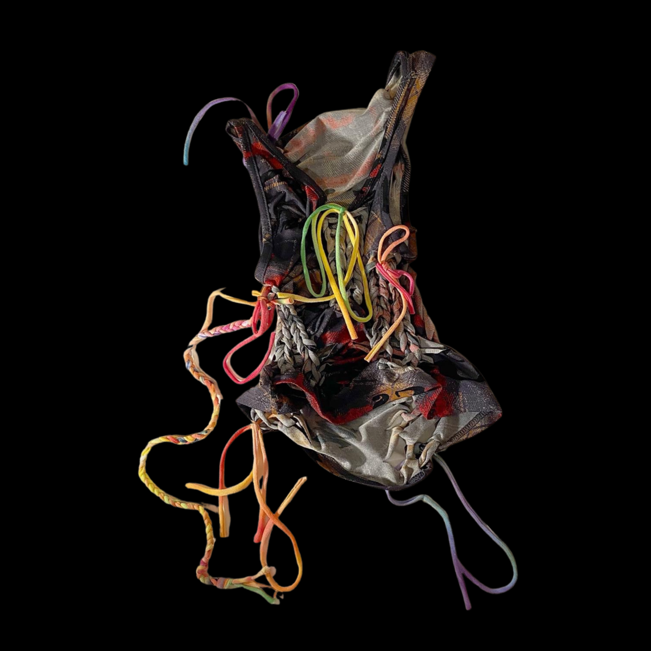 Colorful, crumpled fabric with various tangled shoelaces against a black background.