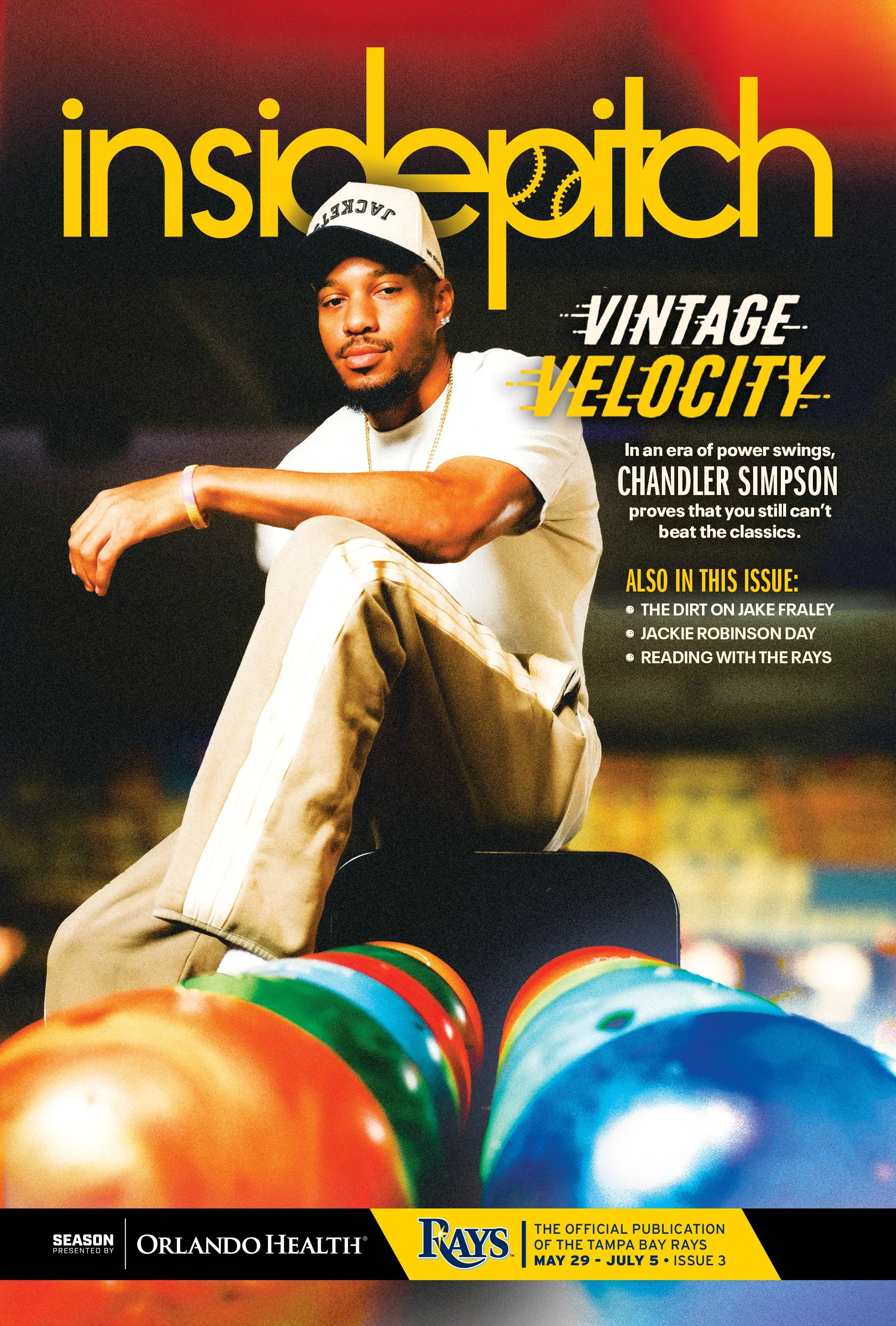 Cover of a Tampa Bay Rays game program featuring Chandler Simpson wearing a white cap and white shirt, with colorful bowling balls in front, and bold yellow and white text about the team and issue dates.