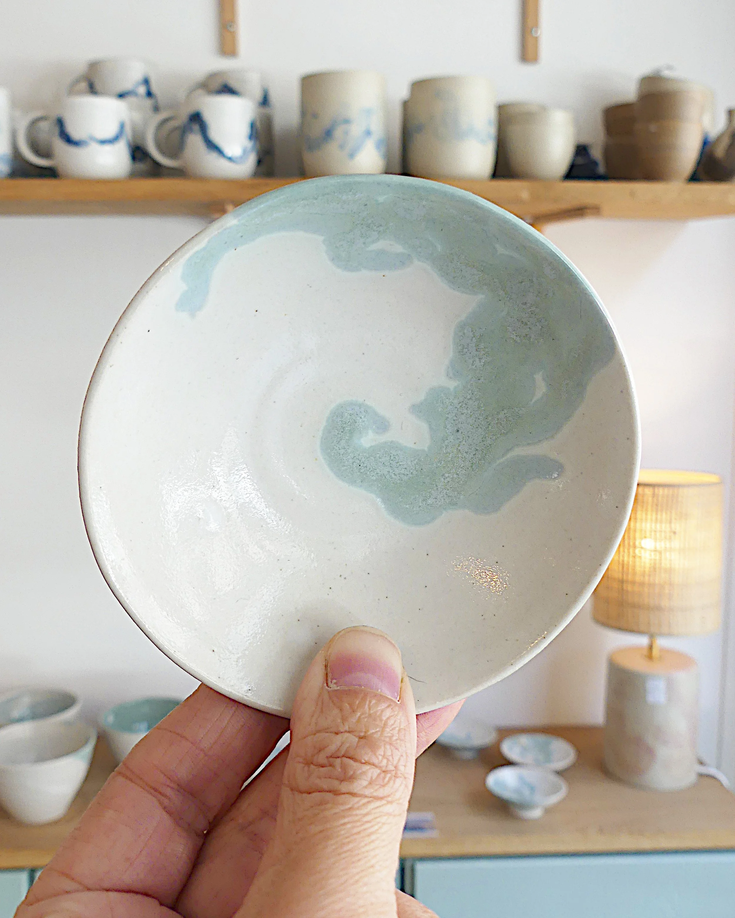 Coupelle blanche avec des décors verts en forme de volutes