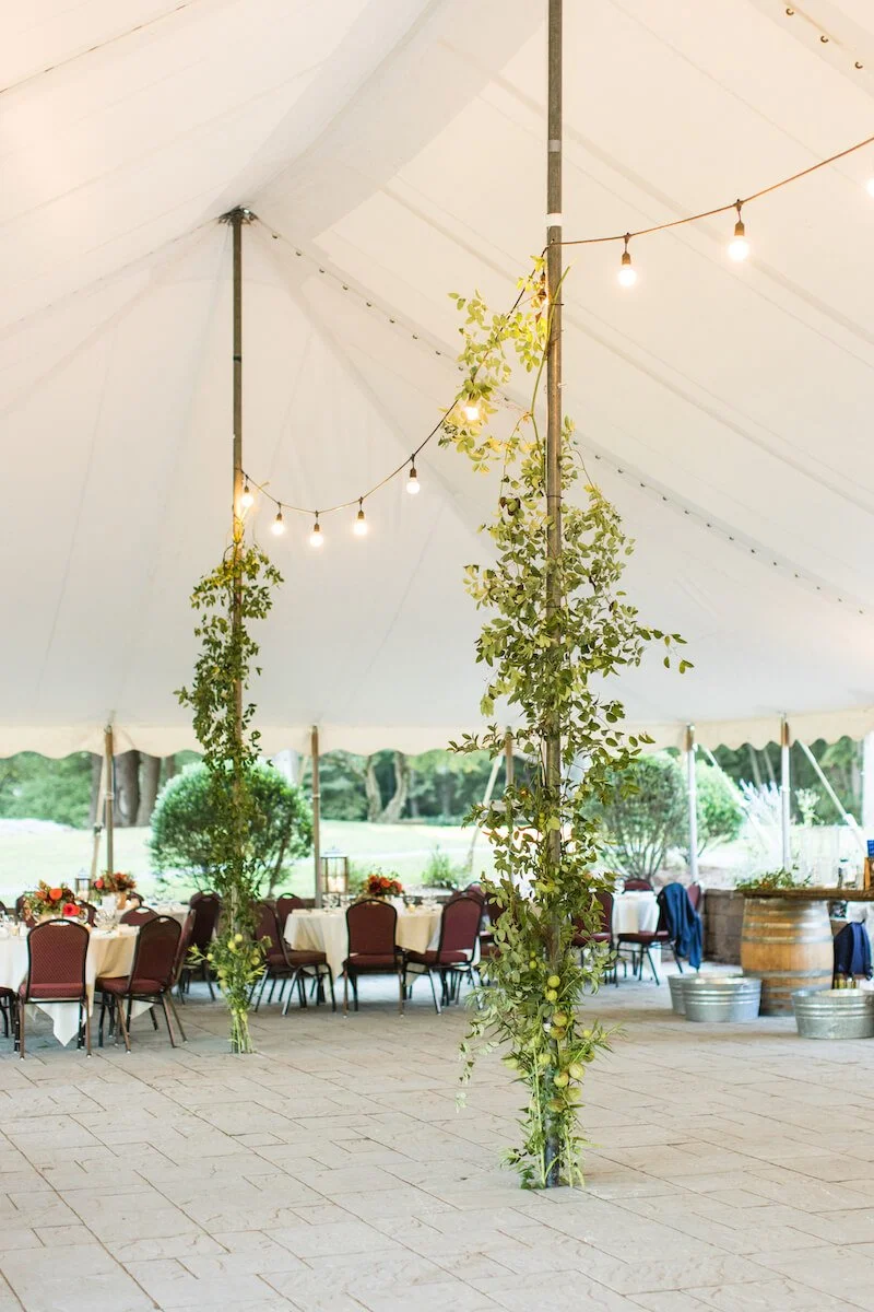 Tent poles decorated with wedding flowers and lights.jpg