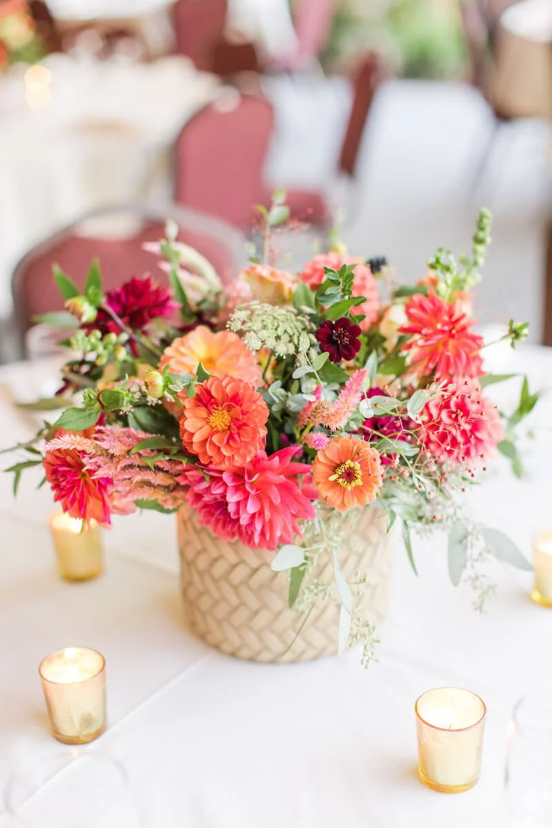 Table arrangement with pinks oranges surrounded by four votives.jpg
