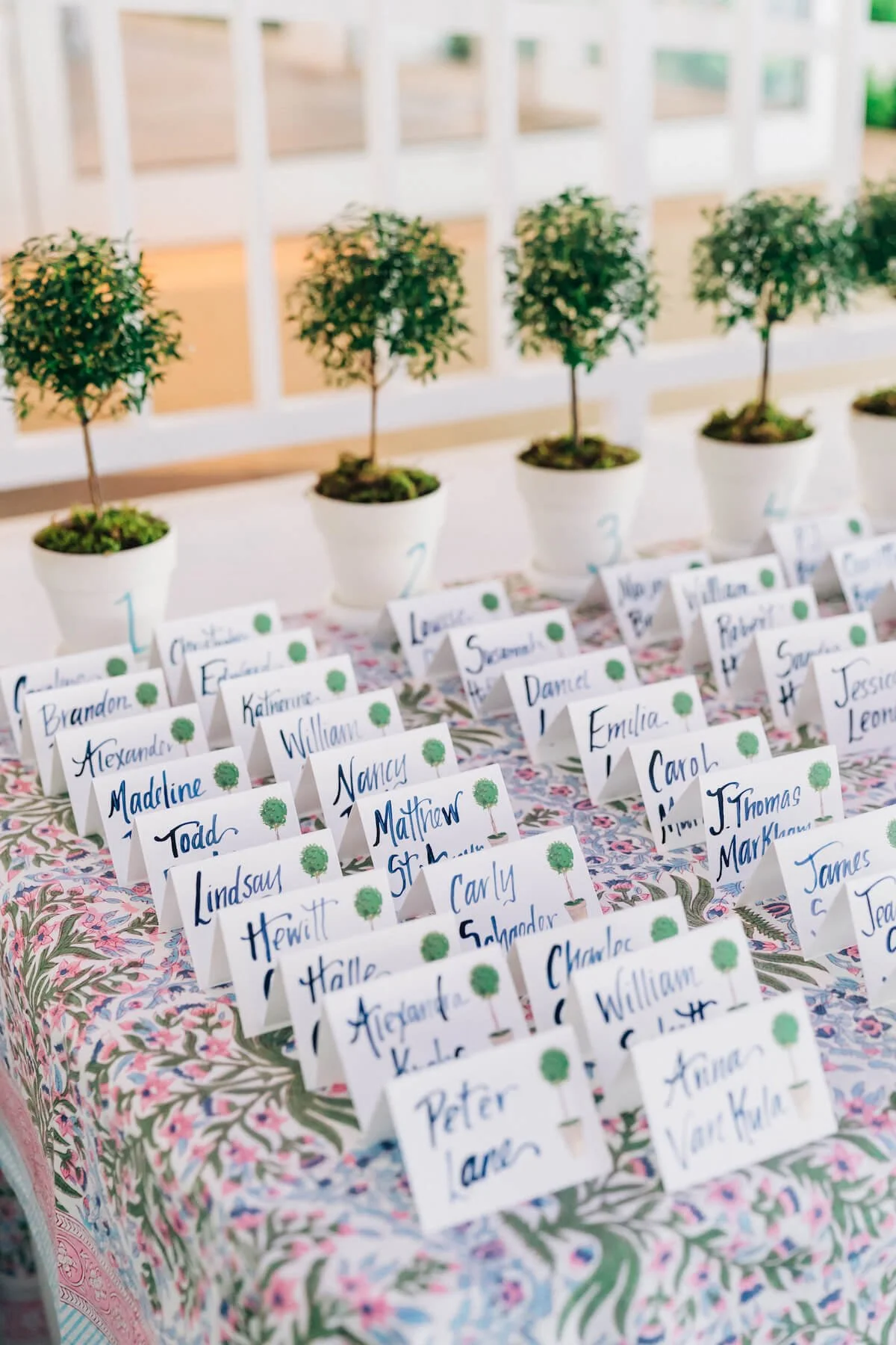 Place card table lined with topiaries at the head.jpg