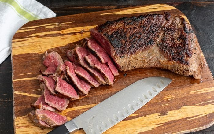 rare-slices-of-tri-tip-steak-on-a-bamboo-cutting-1215400511.jpeg