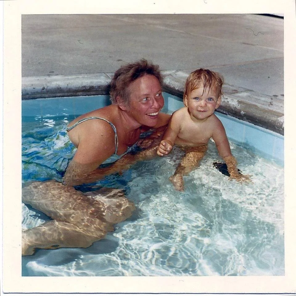 Sarah Waters mother Shurlee with Sarah as a baby, playing in a swimming pool, smiling and enjoying their time together.