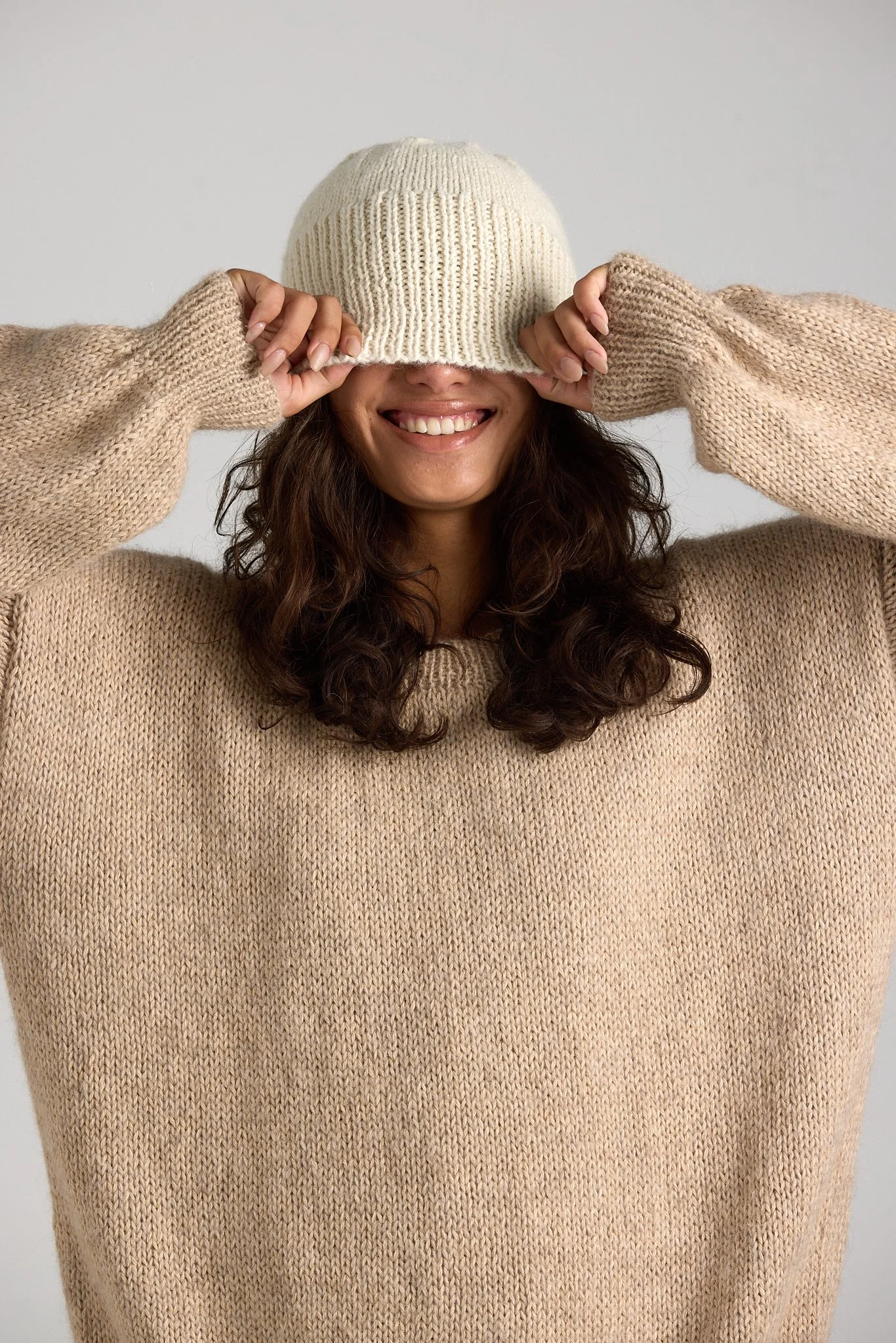 Model wearing First Born Knit in a clean studio setup, blending fashion and beauty aesthetics