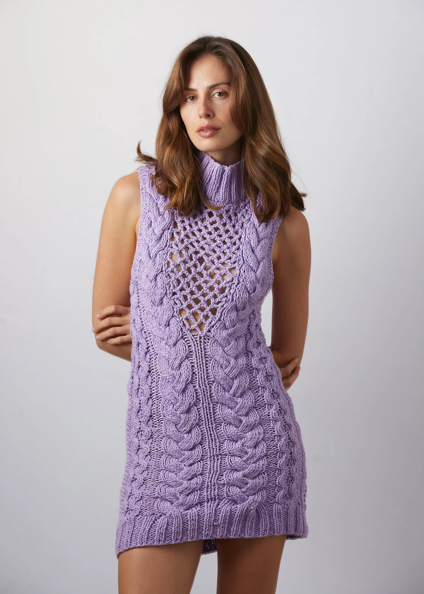 Studio fashion portrait of a woman in a purple knit dress with clean model portfolio styling.