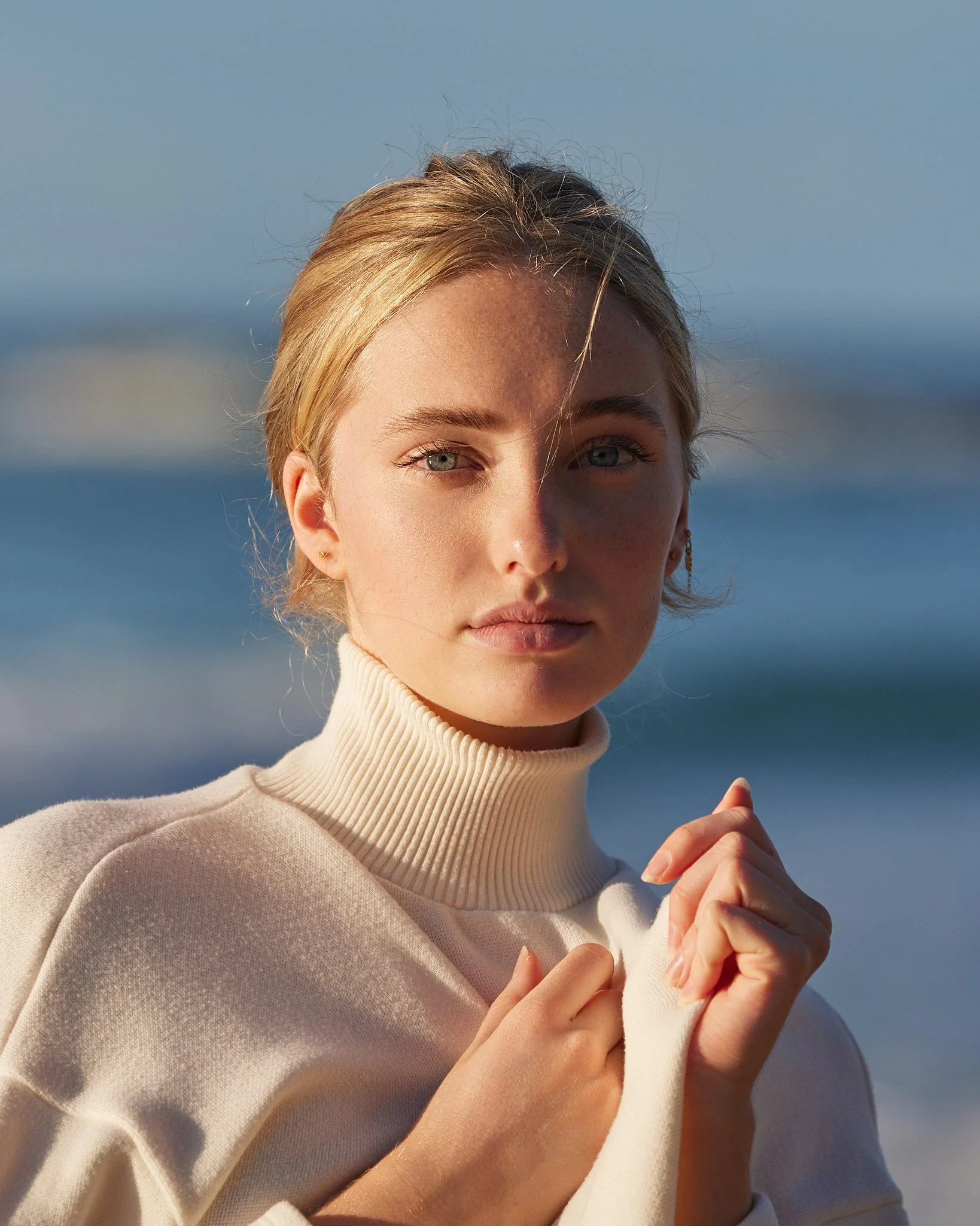 Natural light model portfolio portrait of a woman in a beige turtleneck near the Byron Bay coast.