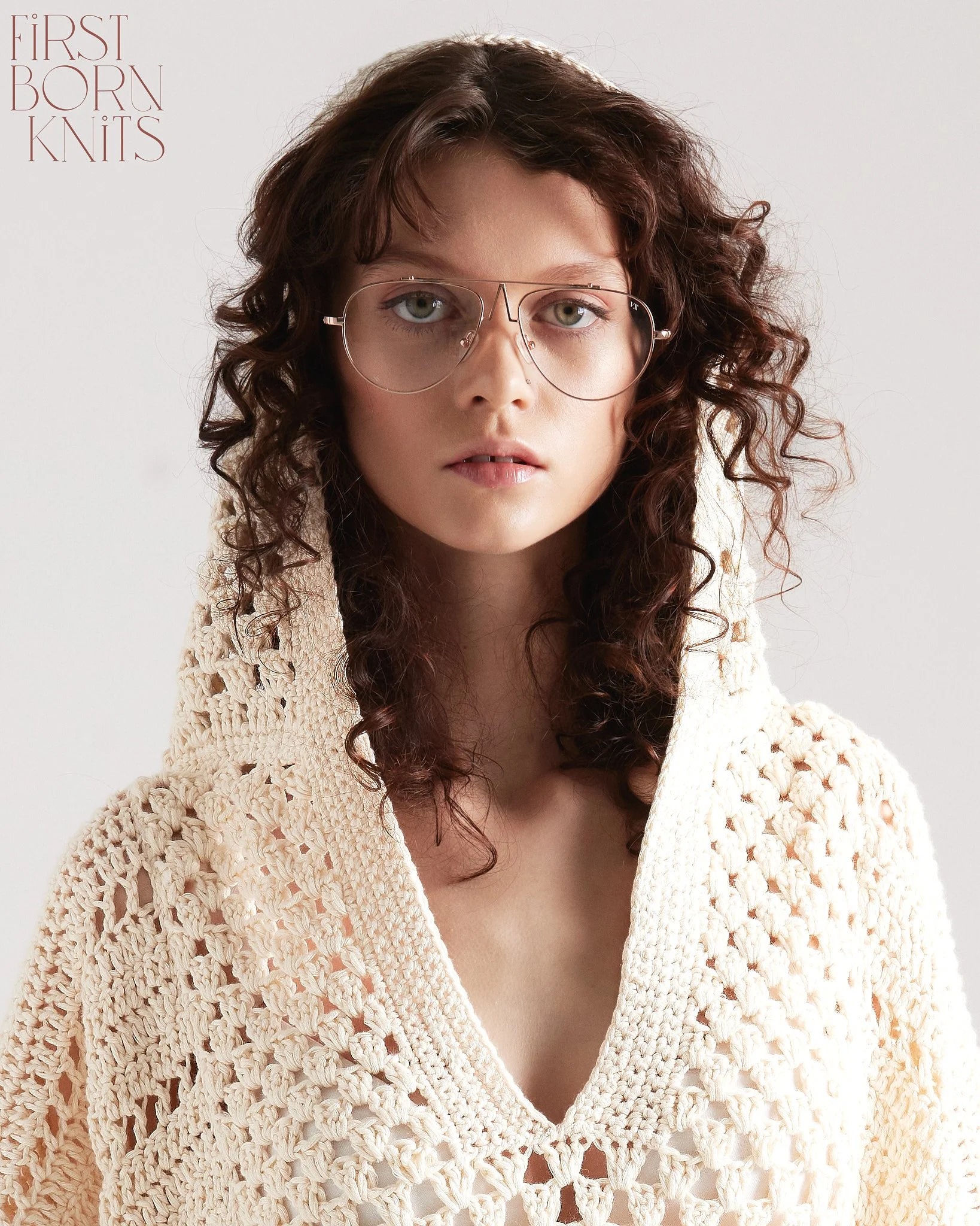  Lookbook-style fashion portrait featuring a cream knit sweater and natural model direction.