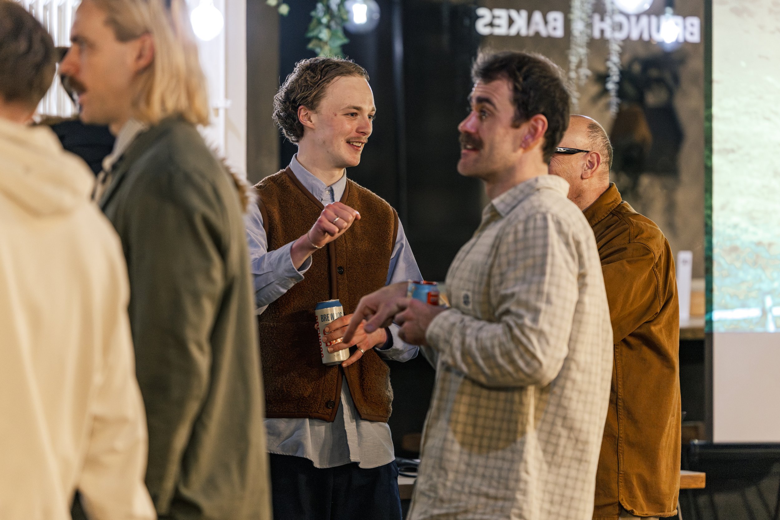 Documentary event photography of guests networking and socialising during the Rapha Cycling Club Awards Night at Northern Pour, Manchester, capturing candid interactions and community atmosphere.