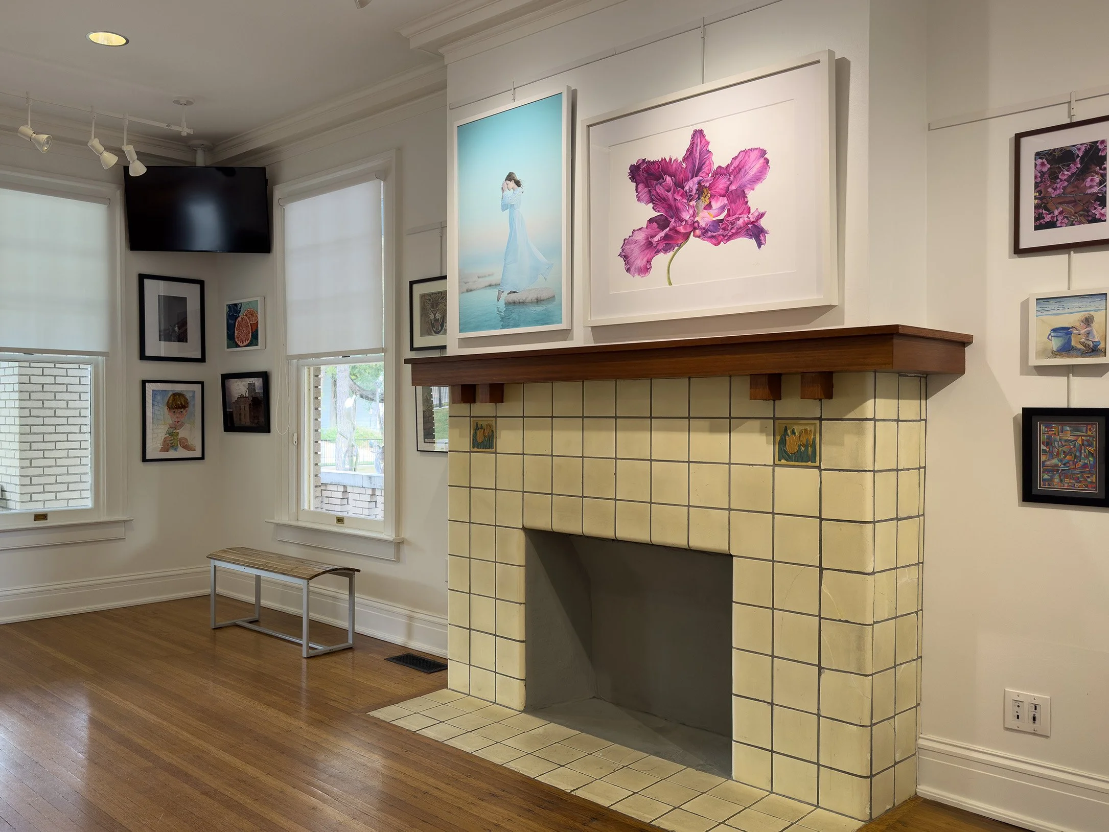 Two artworks displayed over the fireplace mantel at the ArtCentre of Plano.