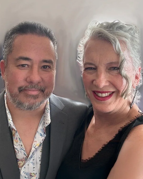 A man and a woman smiling for a selfie, dressed in formal and semi-formal attire.