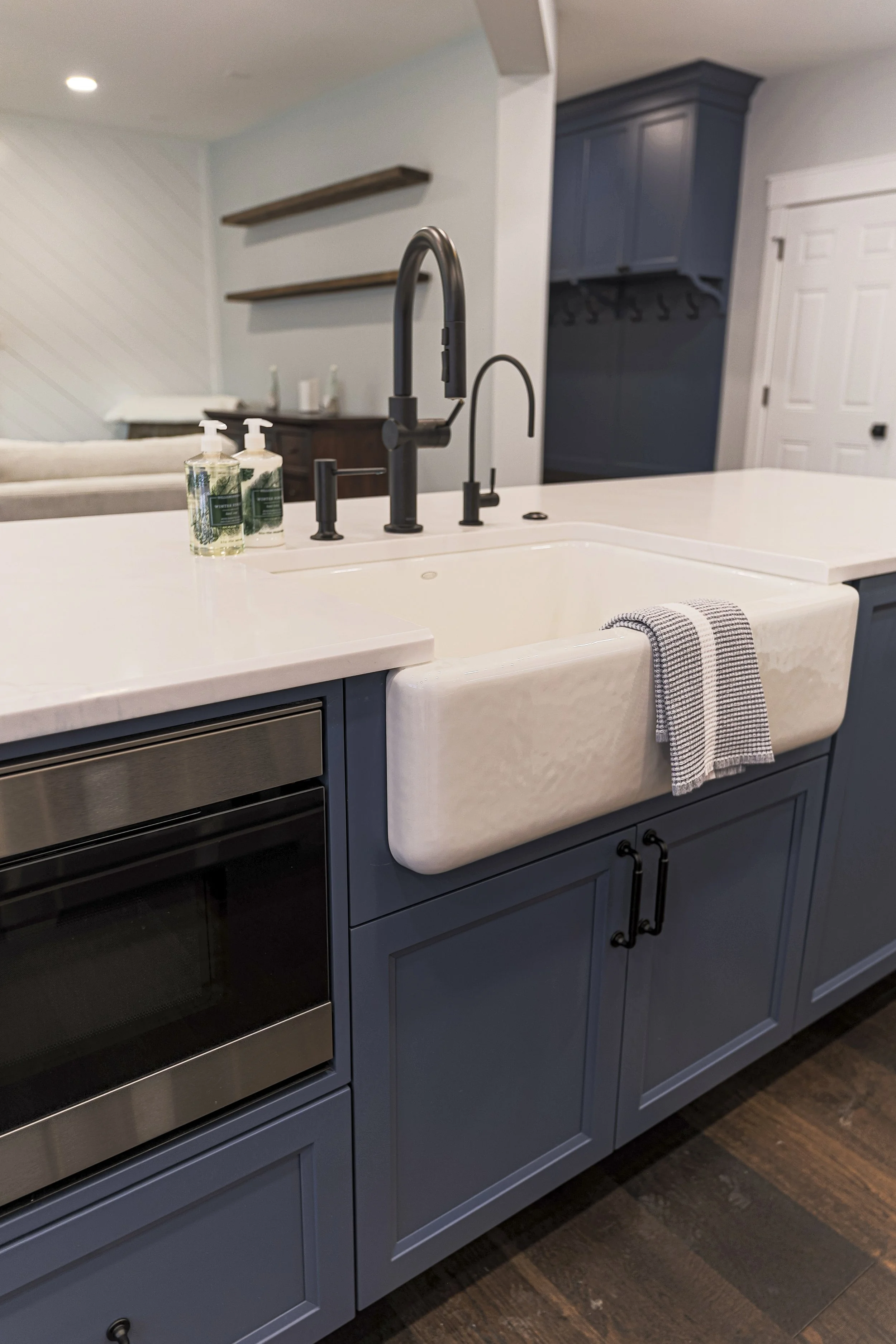 Navy kitchen island with farmhouse sink and microwave drawer in a Doylestown kitchen remodel