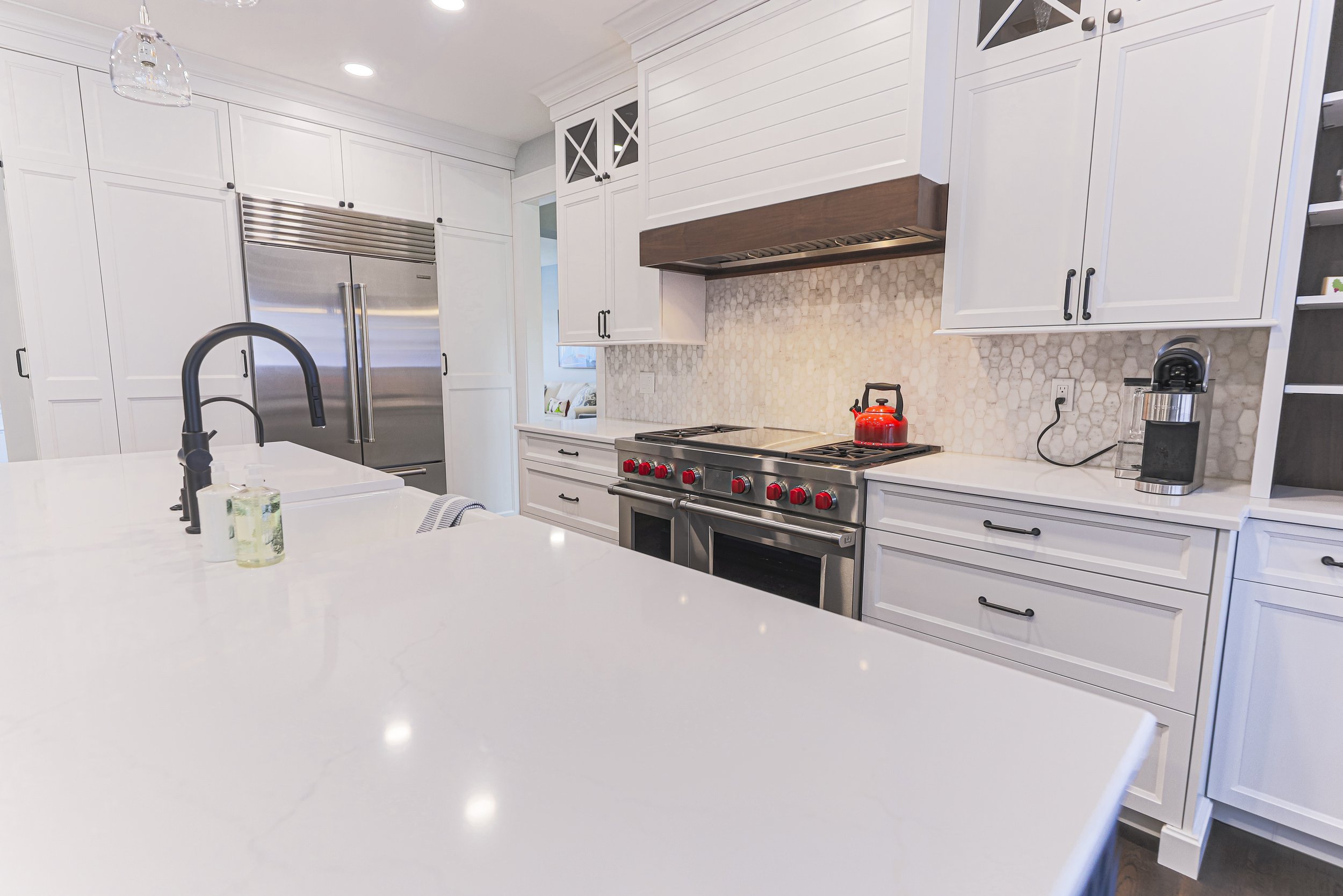 White quartz island and range wall with patterned tile backsplash