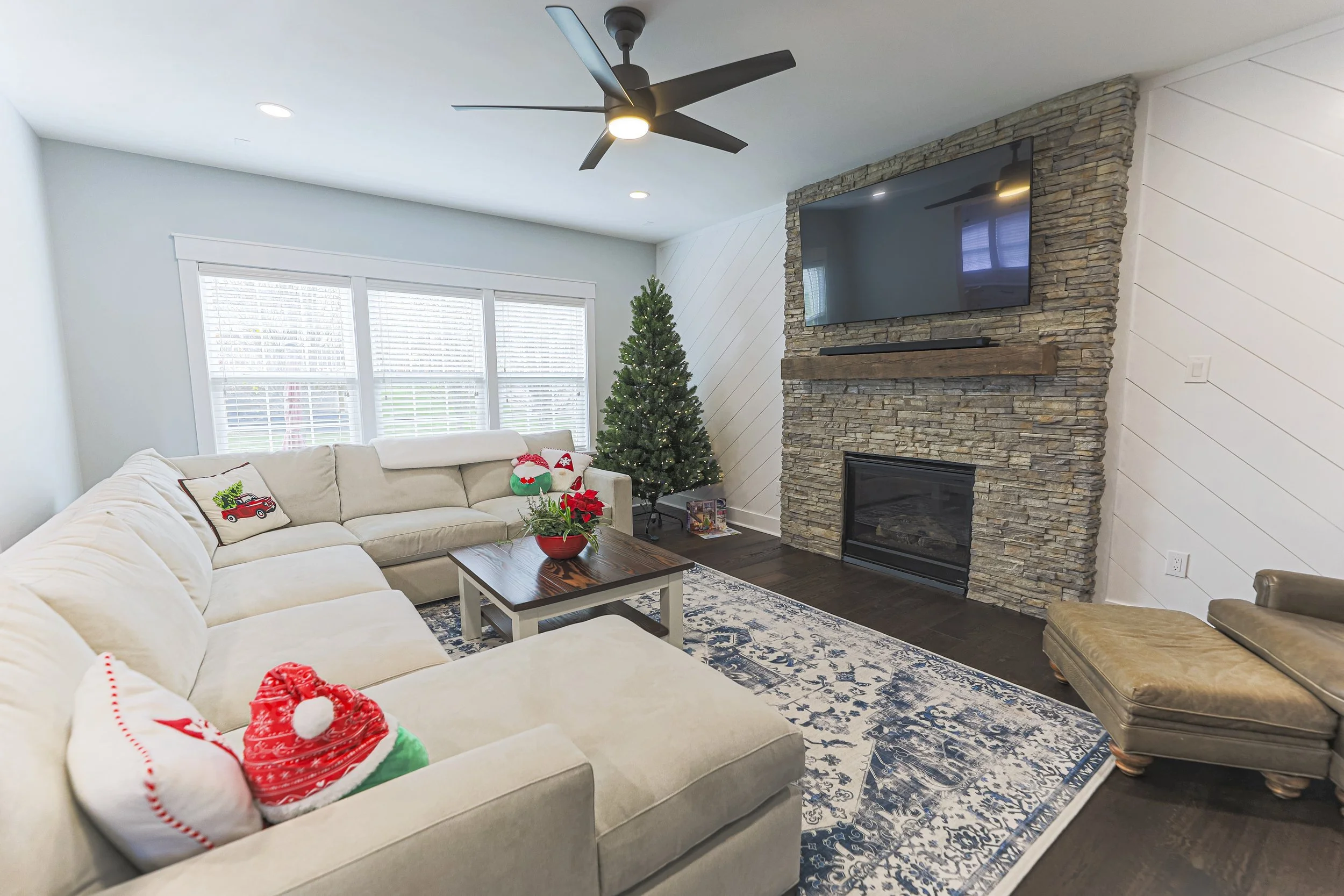 Family room with sectional sofa, stone fireplace and ceiling fan in a Doylestown renovation