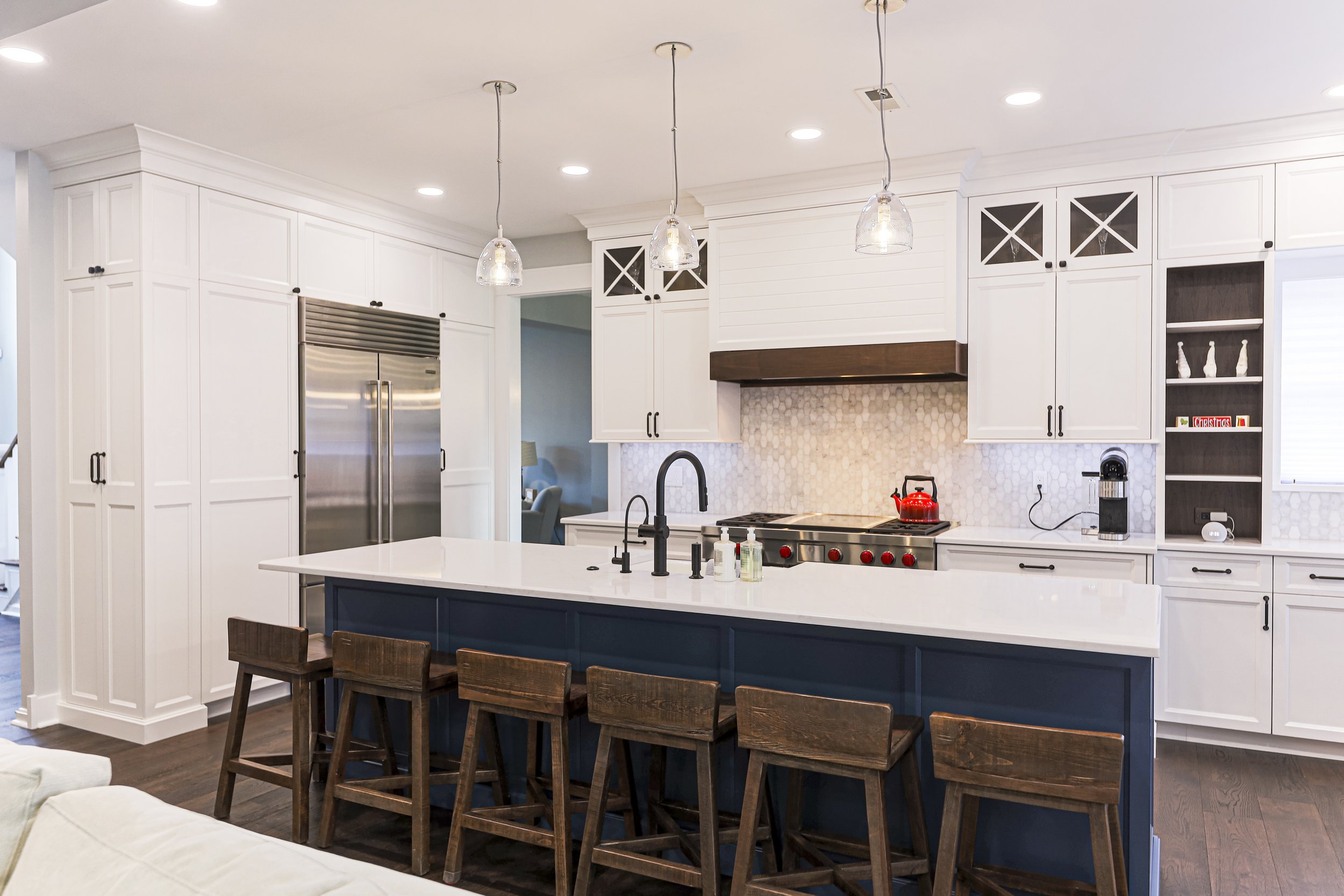 Doylestown kitchen remodel with white cabinetry, navy island and glass pendant lights