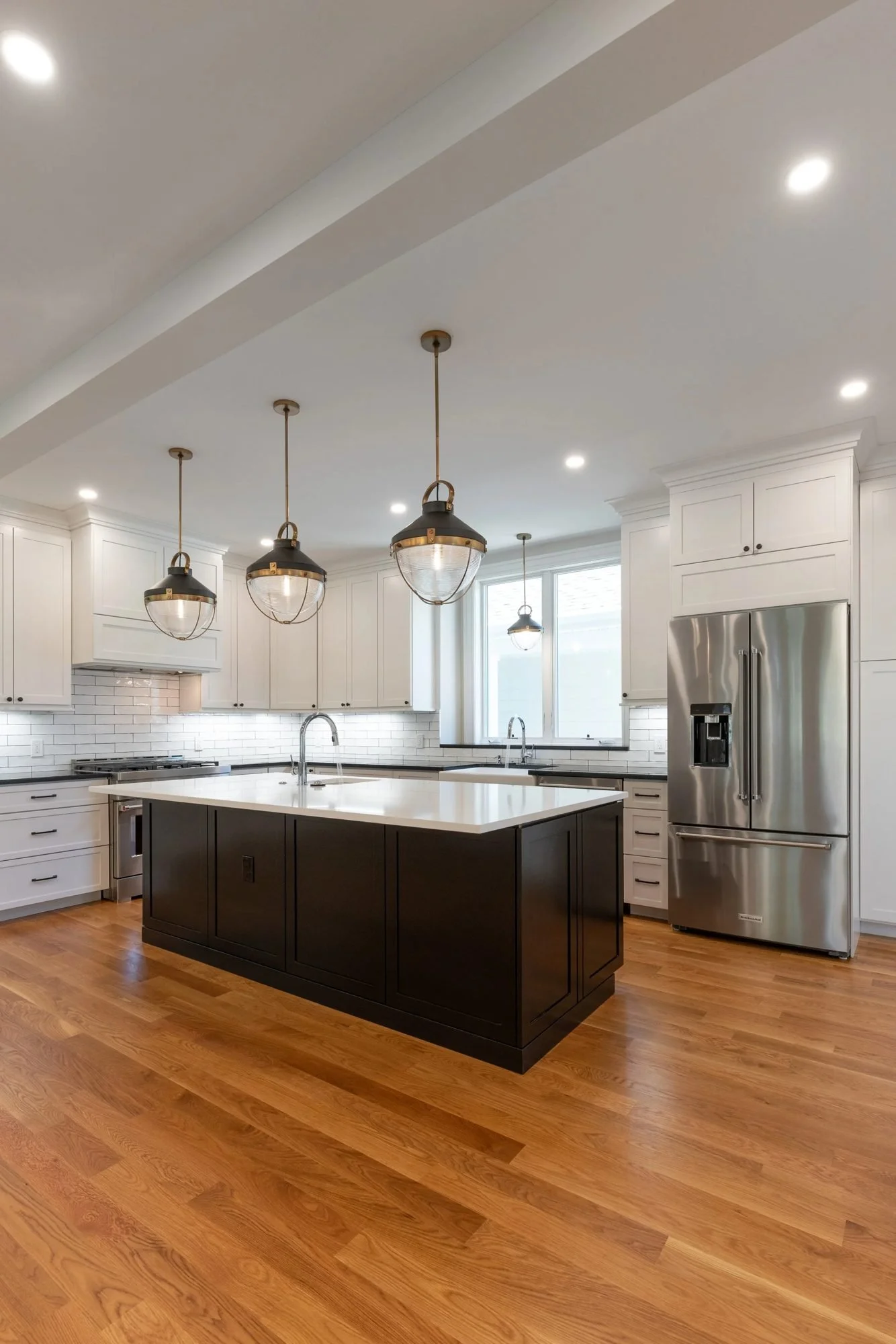 New build kitchen with white oak floors and a dark-stained island