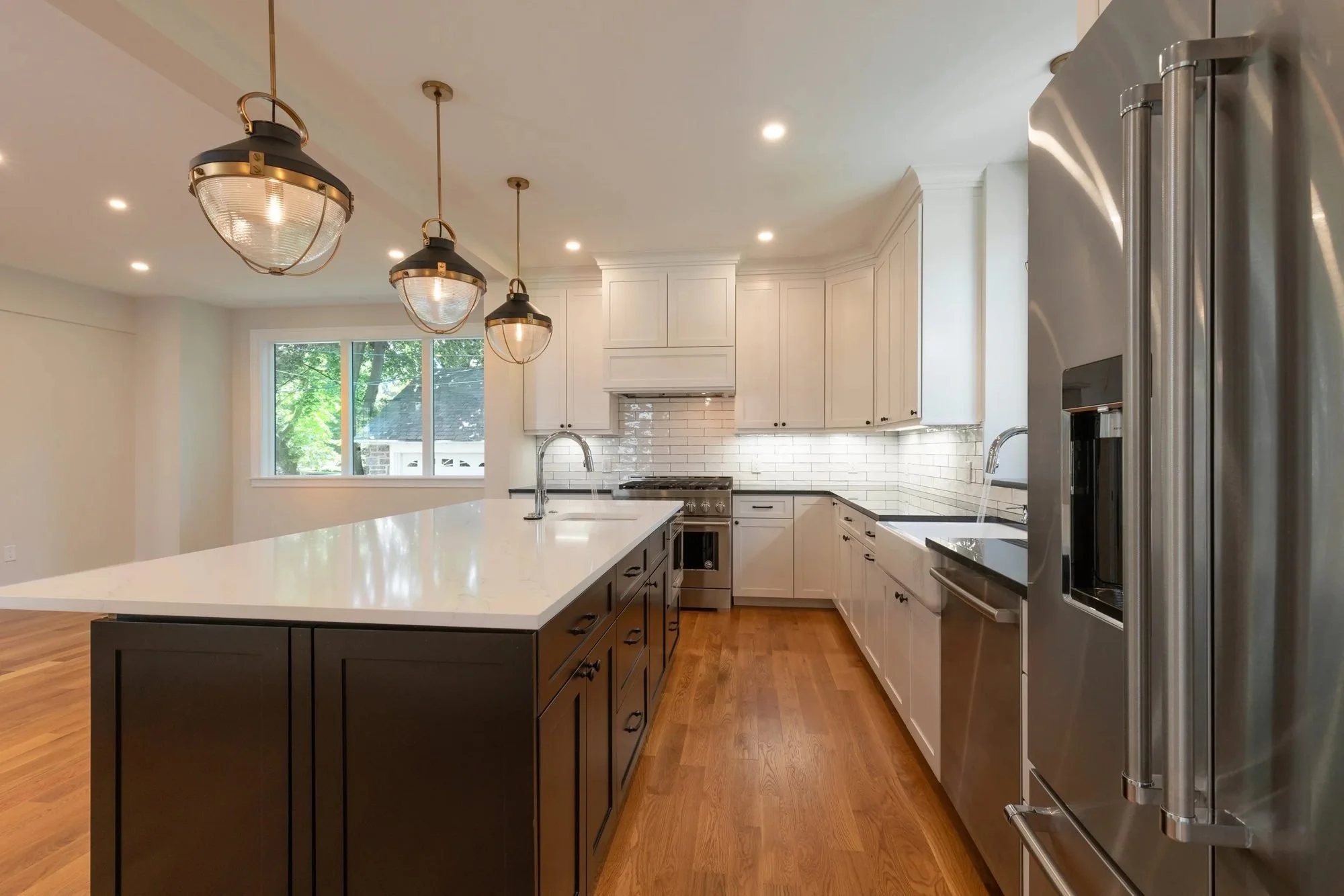 Quartz-topped island beside a stainless French-door refrigerator