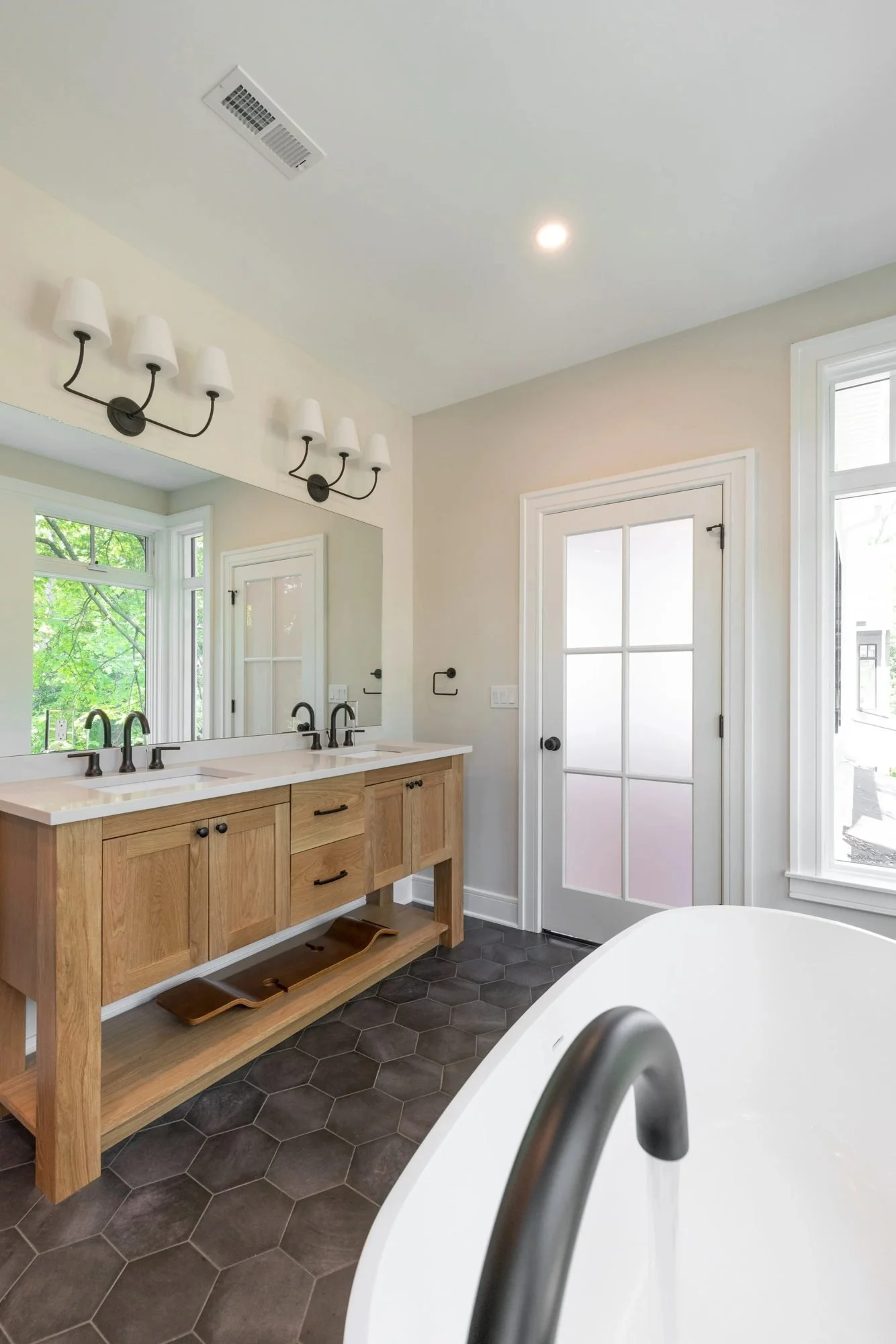 White oak vanity with matte black fixtures and sconces