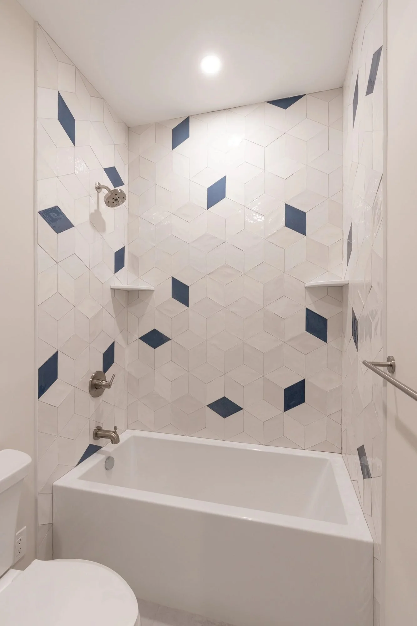 Tub-shower with white tile and navy diamond accents