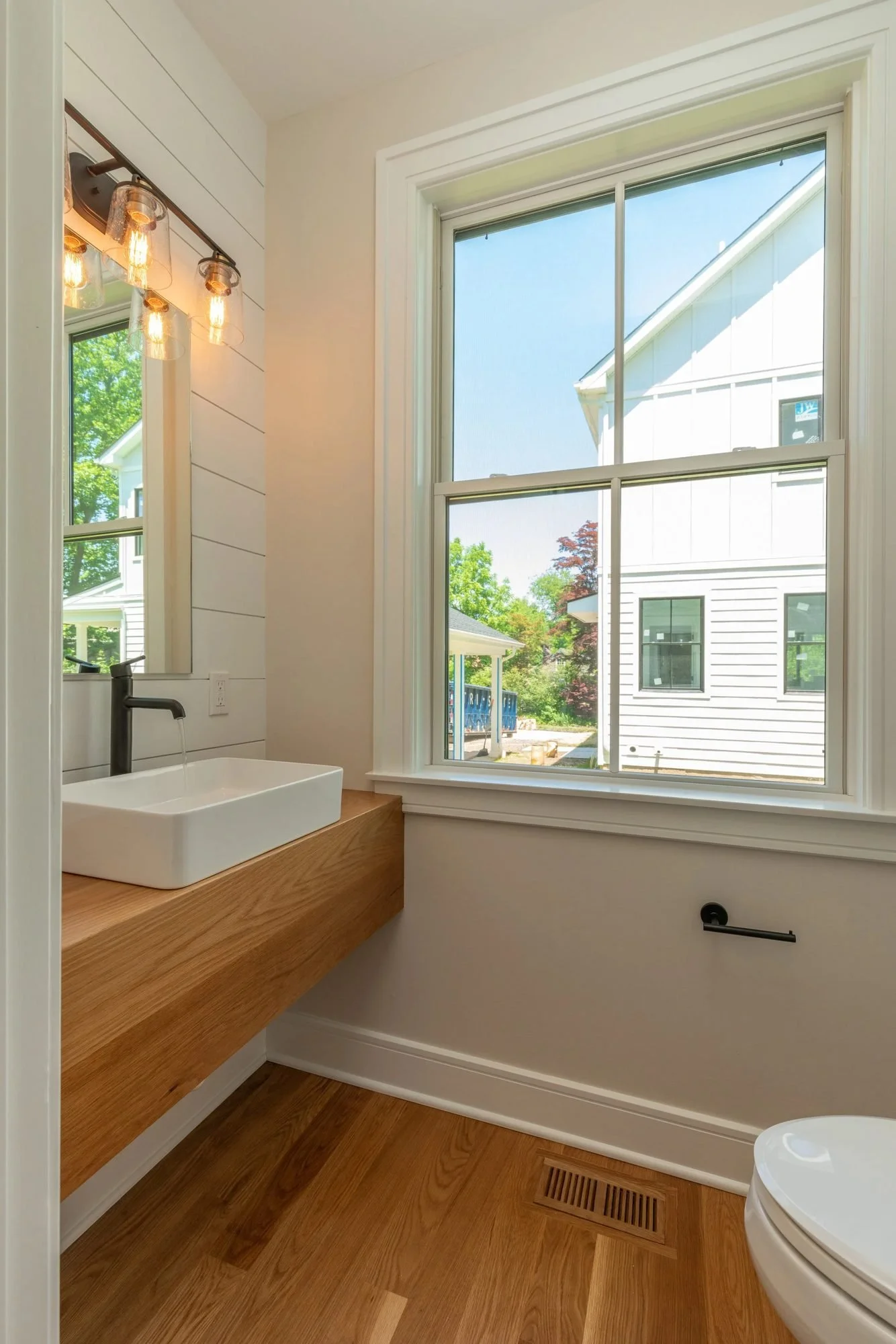Powder room with floating wood vanity and vessel sink