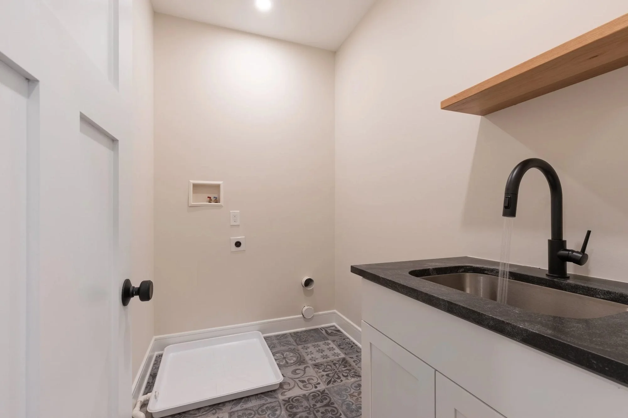 Laundry room with black sink, matte black faucet and wood shelf