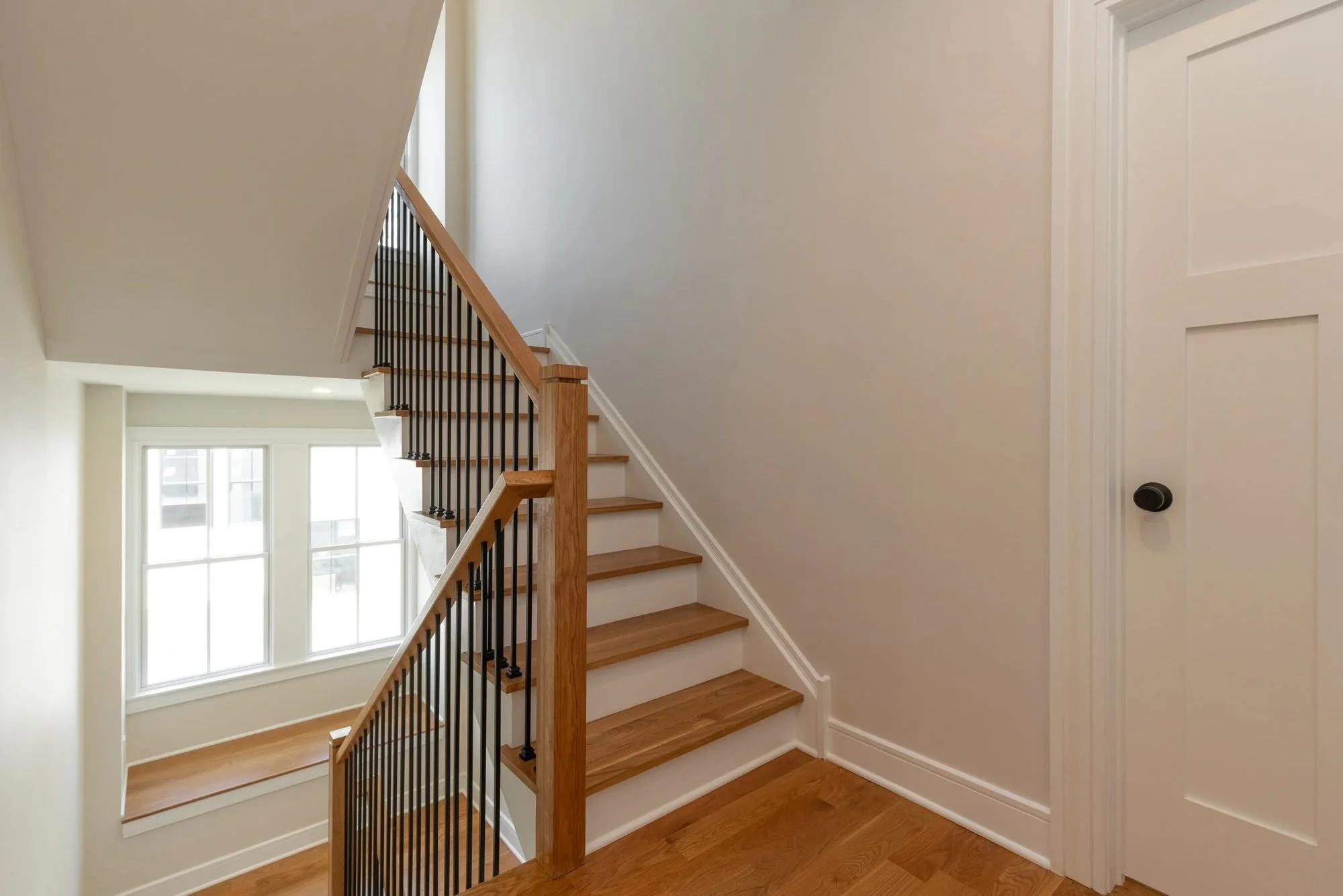 Staircase landing with a window and iron railing