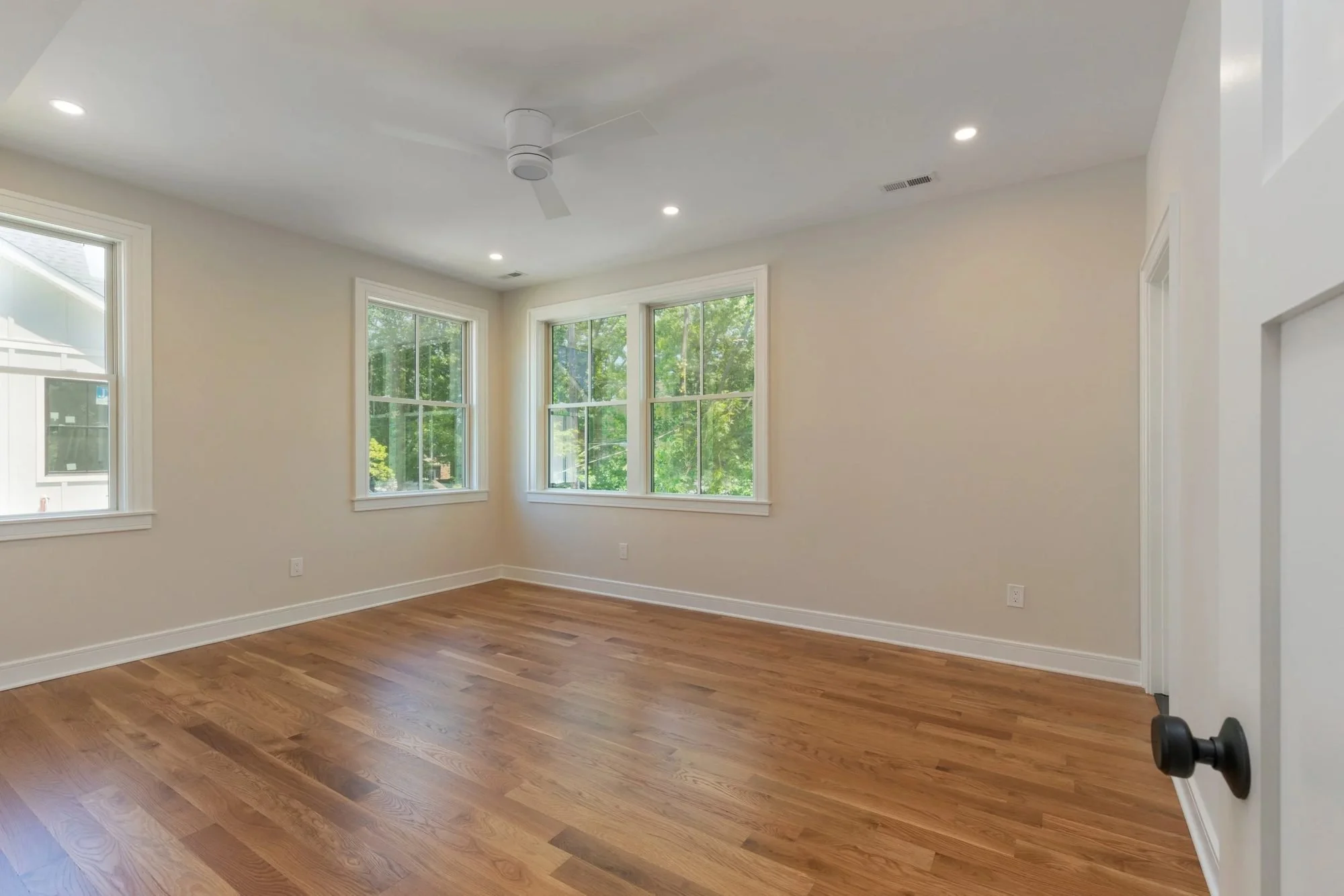 Bedroom with ceiling fan and corner windows