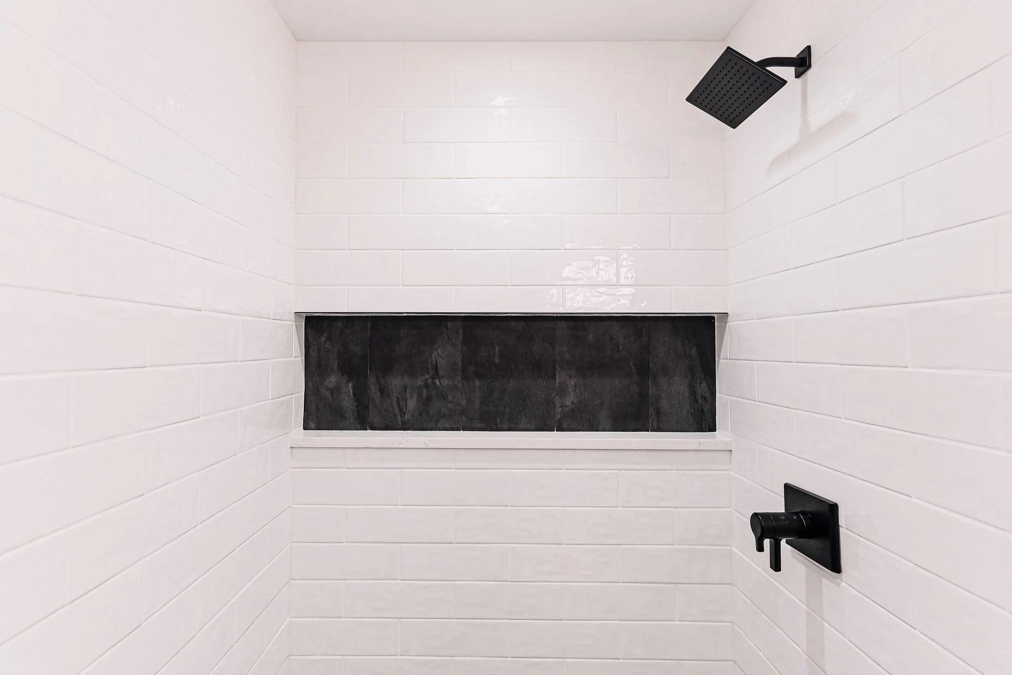 White tile walk-in shower with a long black tile niche in a Bucks County bathroom remodel