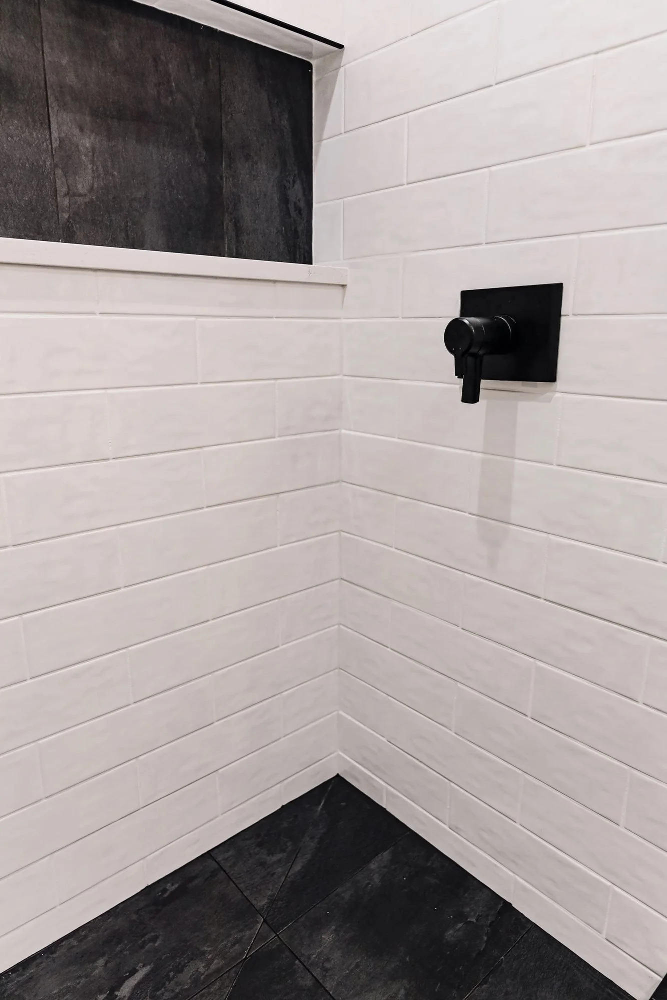 Shower corner with black tile niche and matte black valve