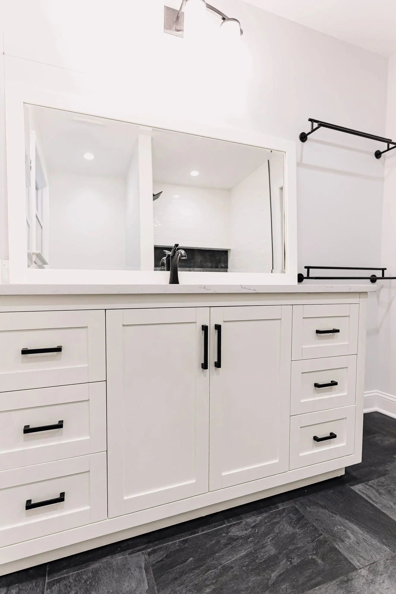 White shaker vanity with matte black hardware and towel bar