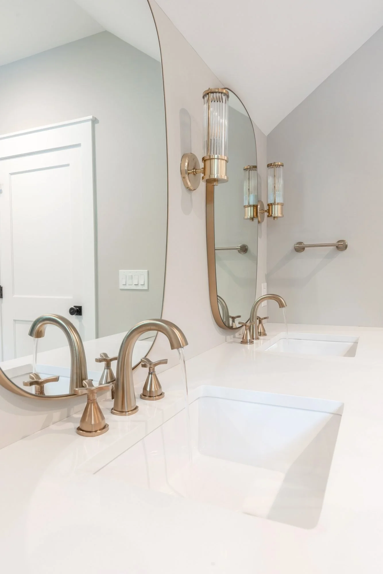 Brushed brass faucet on a white quartz vanity