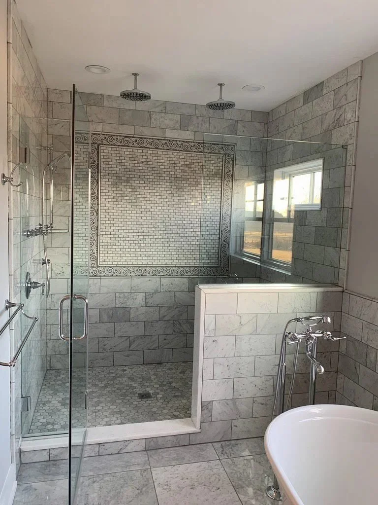 Glass-enclosed shower with gray subway tile in a Doylestown bathroom renovation