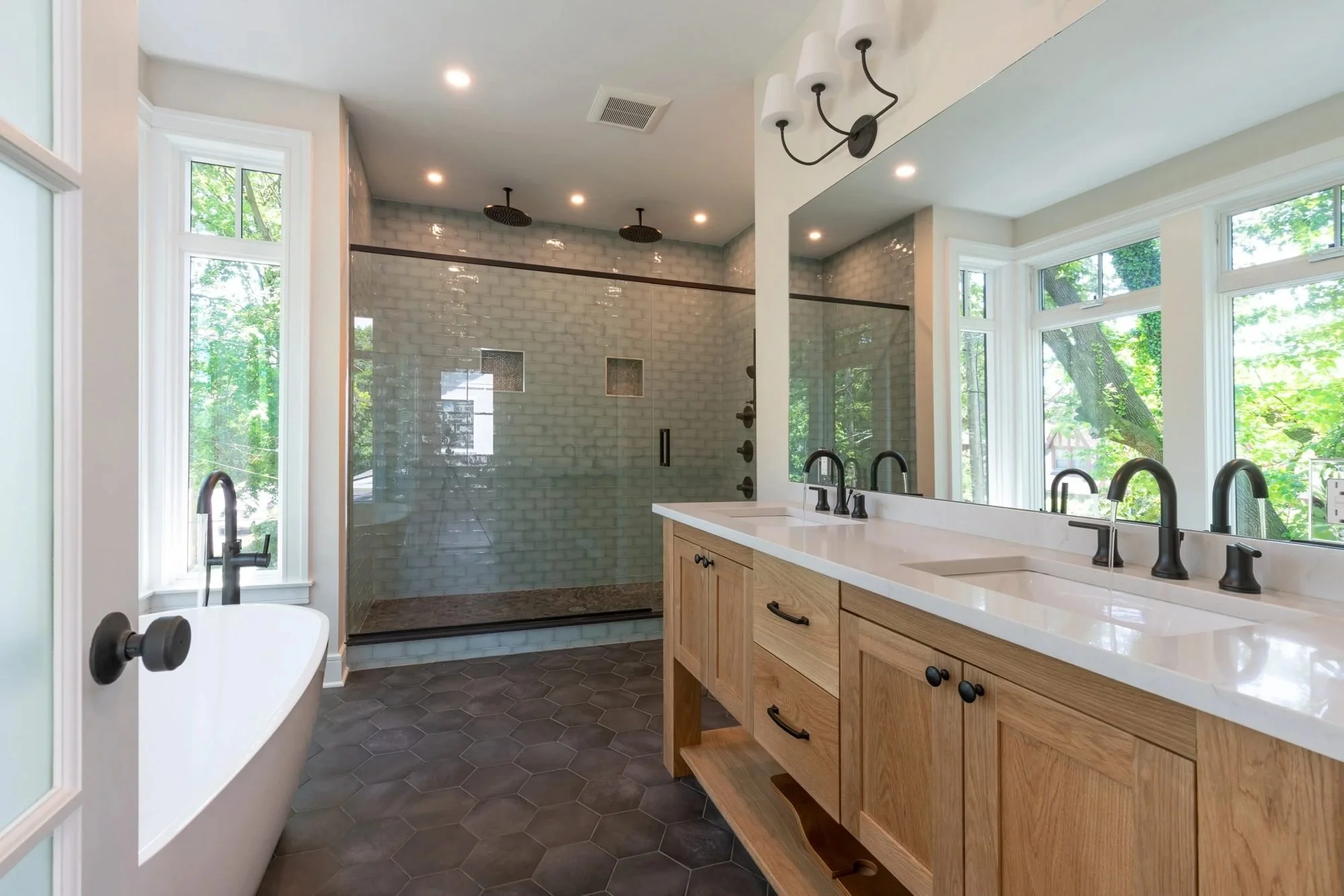 Primary bathroom with freestanding tub, walk-in shower and oak vanity