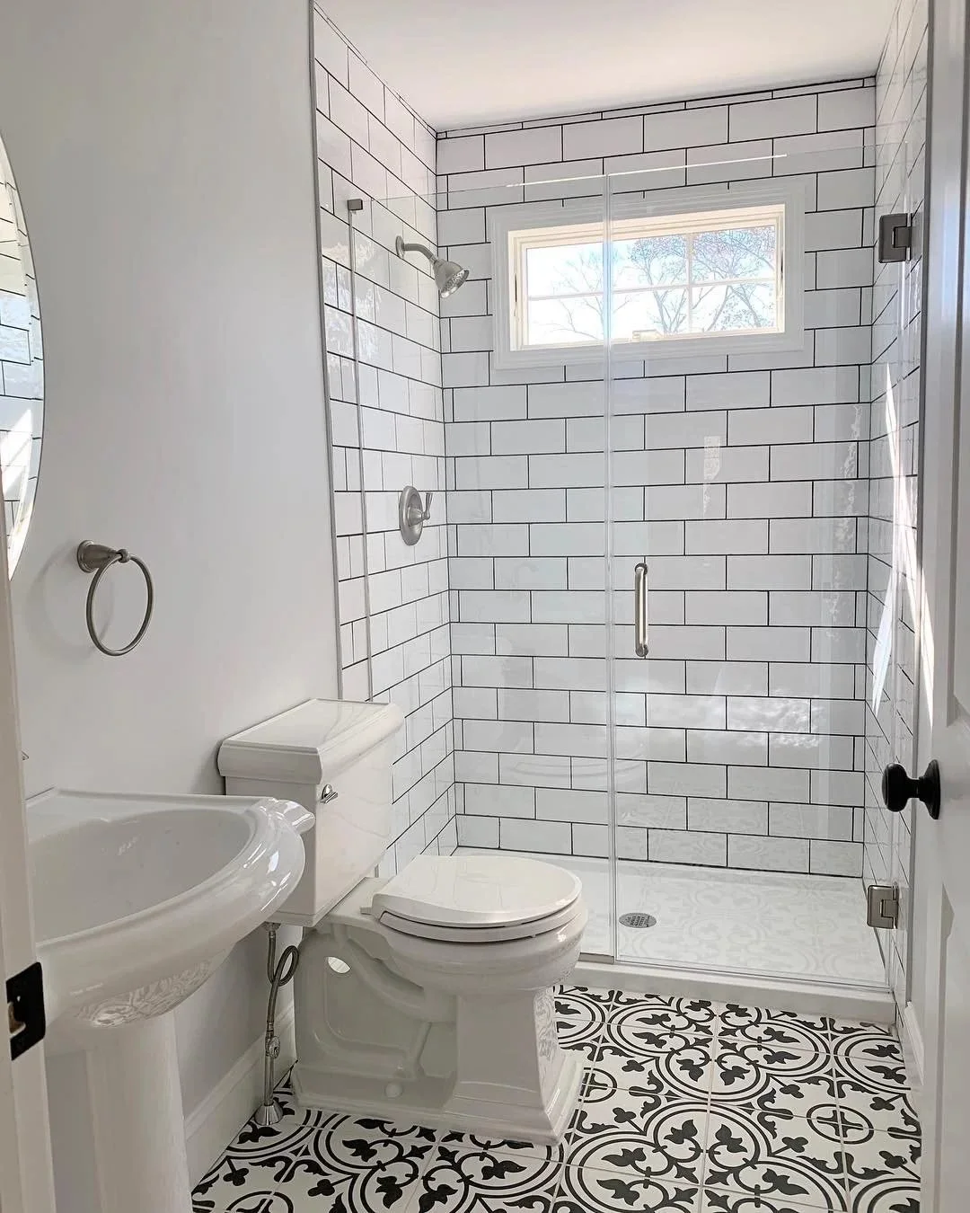 Hall bathroom with white subway tile shower and black-and-white patterned floor