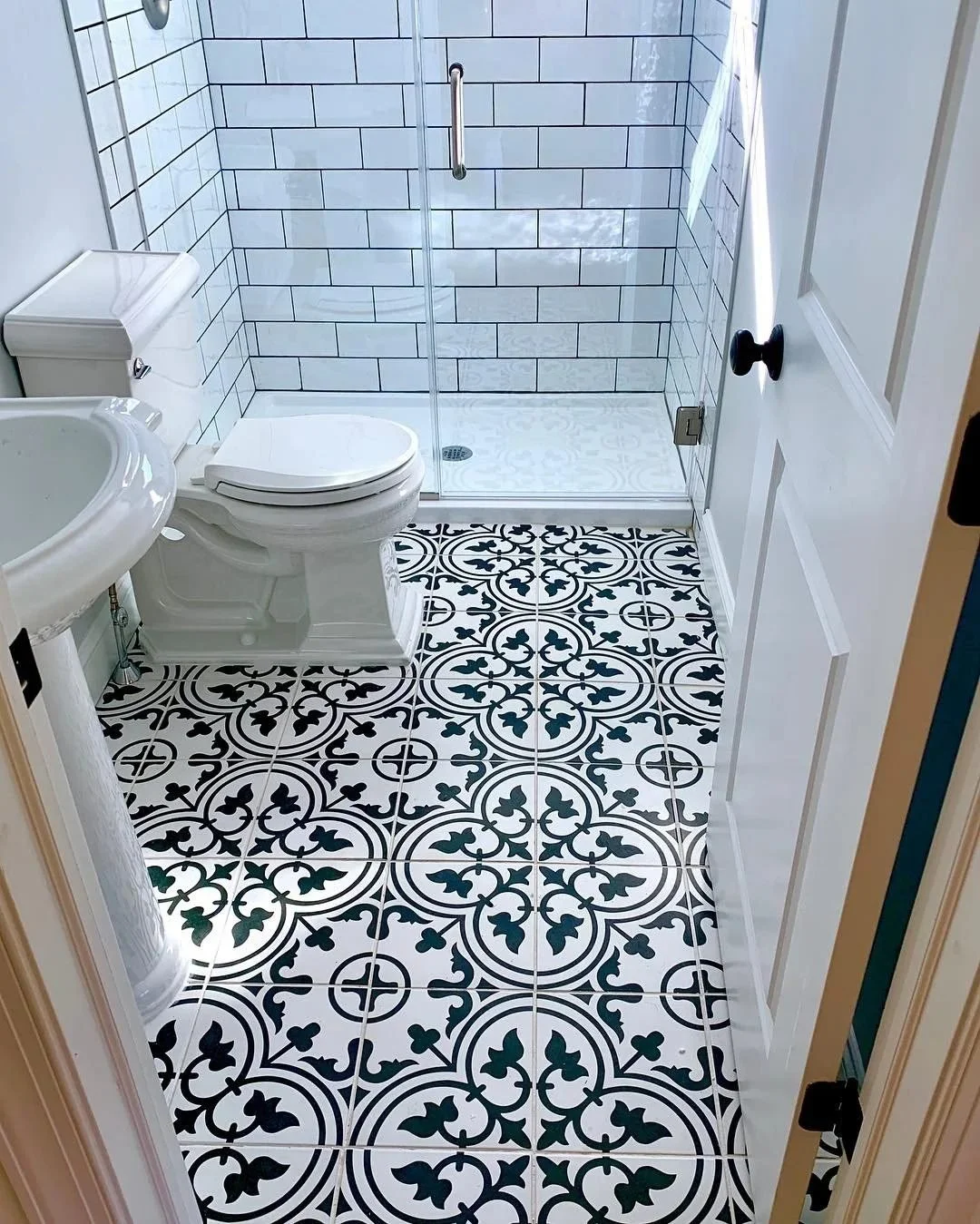 Black-and-white encaustic-look tile floor in a remodeled bathroom