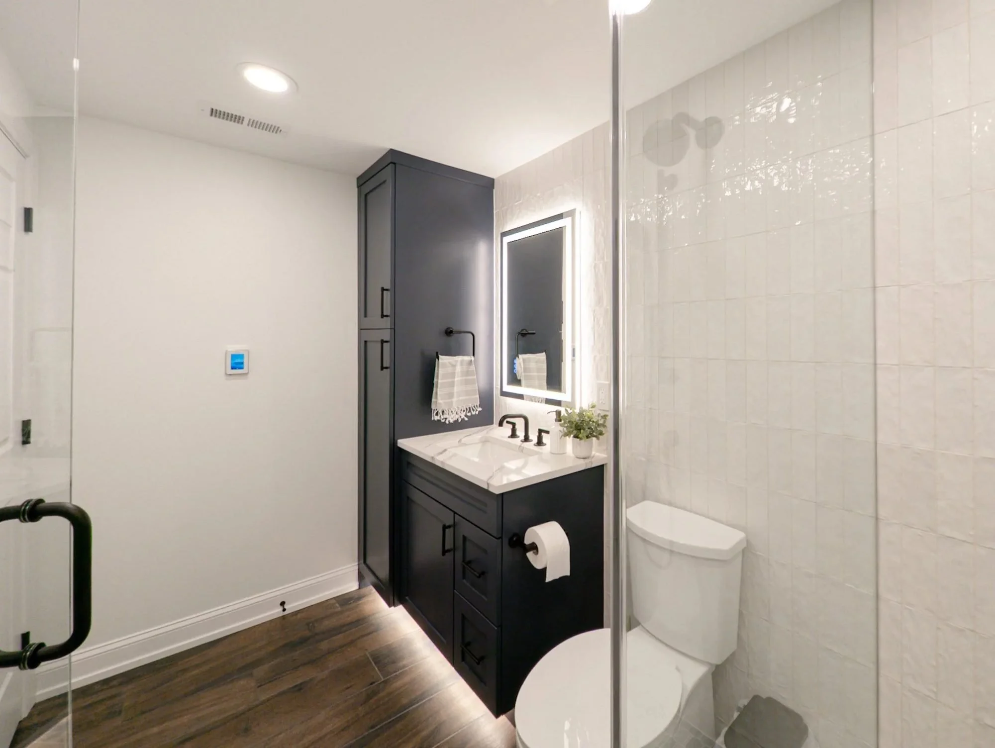 Basement bathroom navy vanity with under-cabinet lighting