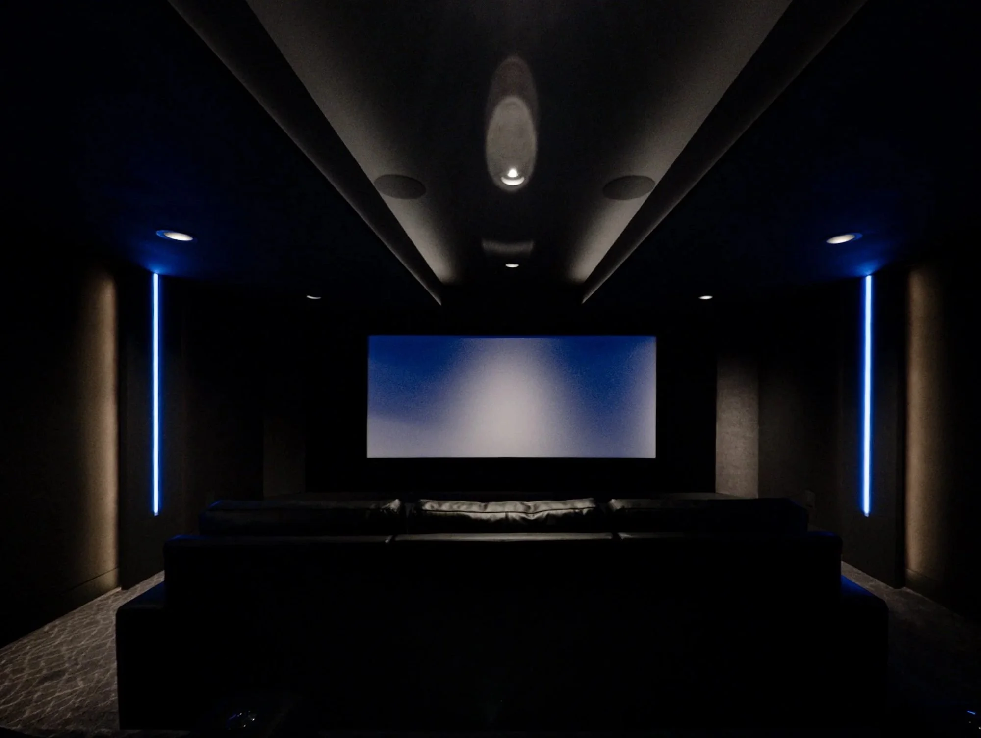 Finished basement home theater in Bucks County with tray ceiling and accent lighting